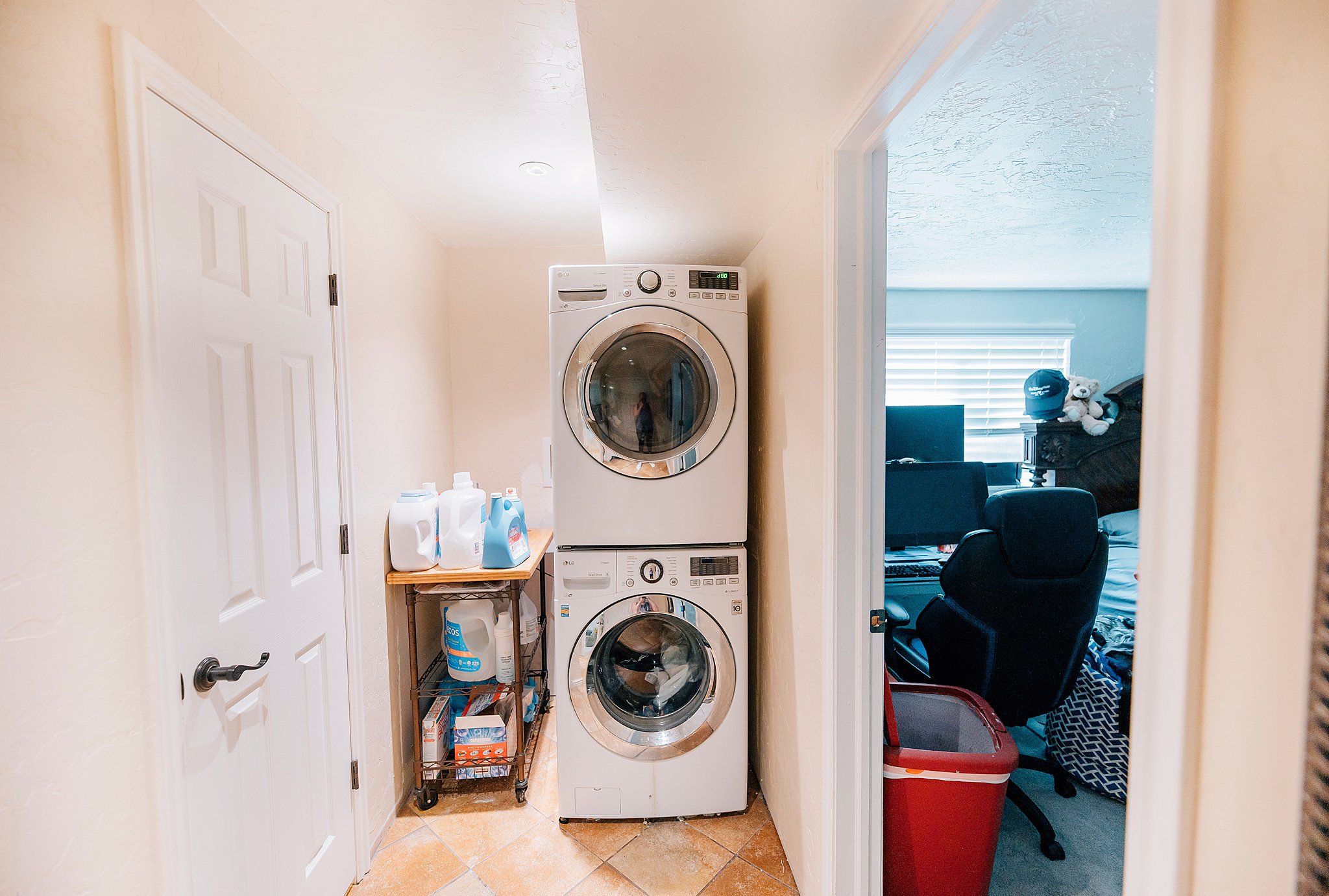 Laundry area with stacked appliances and tiled flooring