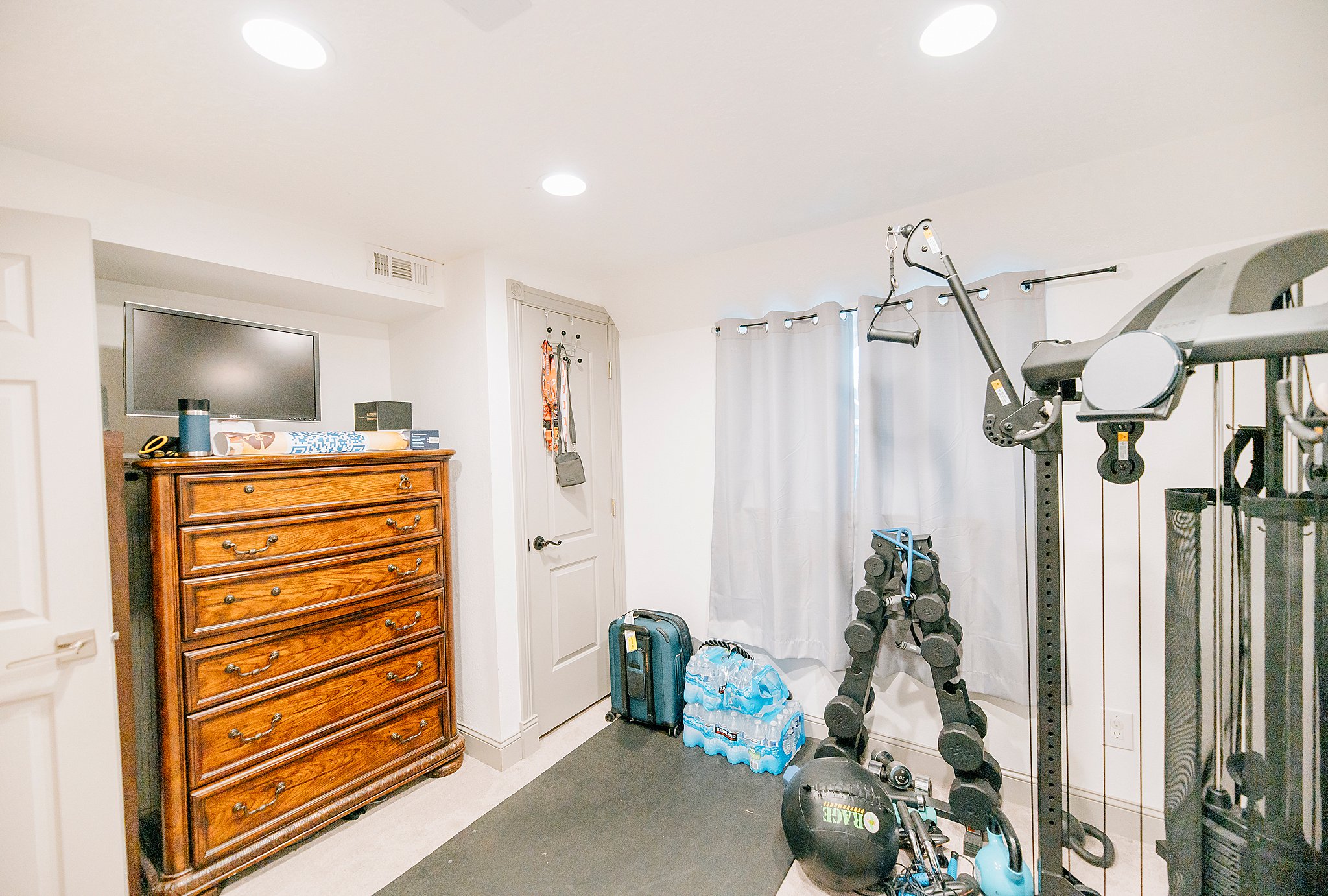 Recessed lighting illuminates a versatile room with light-toned walls