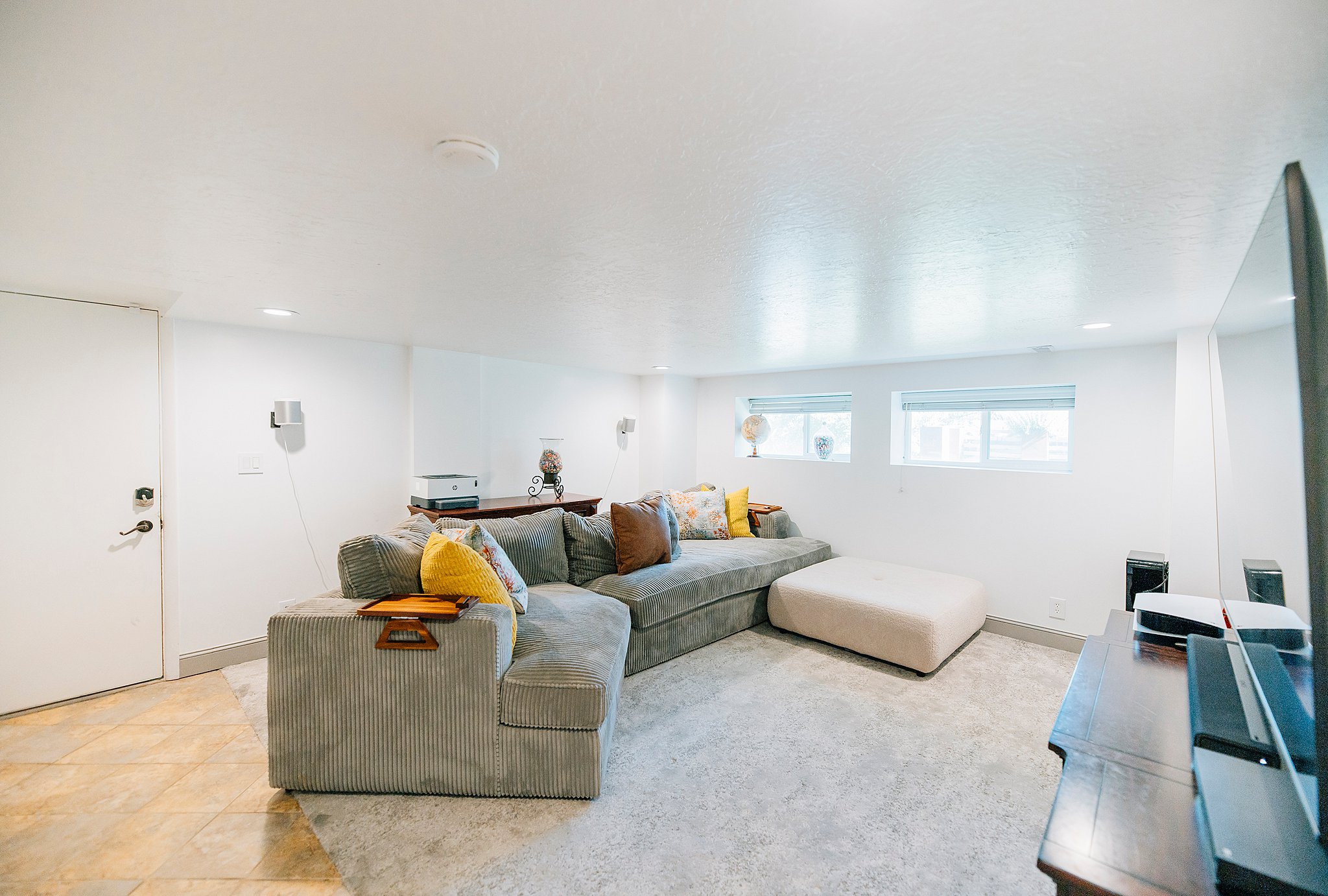 Spacious room featuring recessed lighting, a white painted door, and two high-set windows