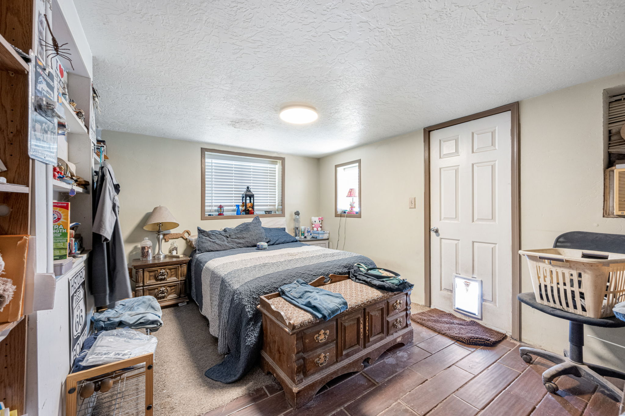 Room featuring wood-finish flooring, textured white ceiling, and a multi-paneled door