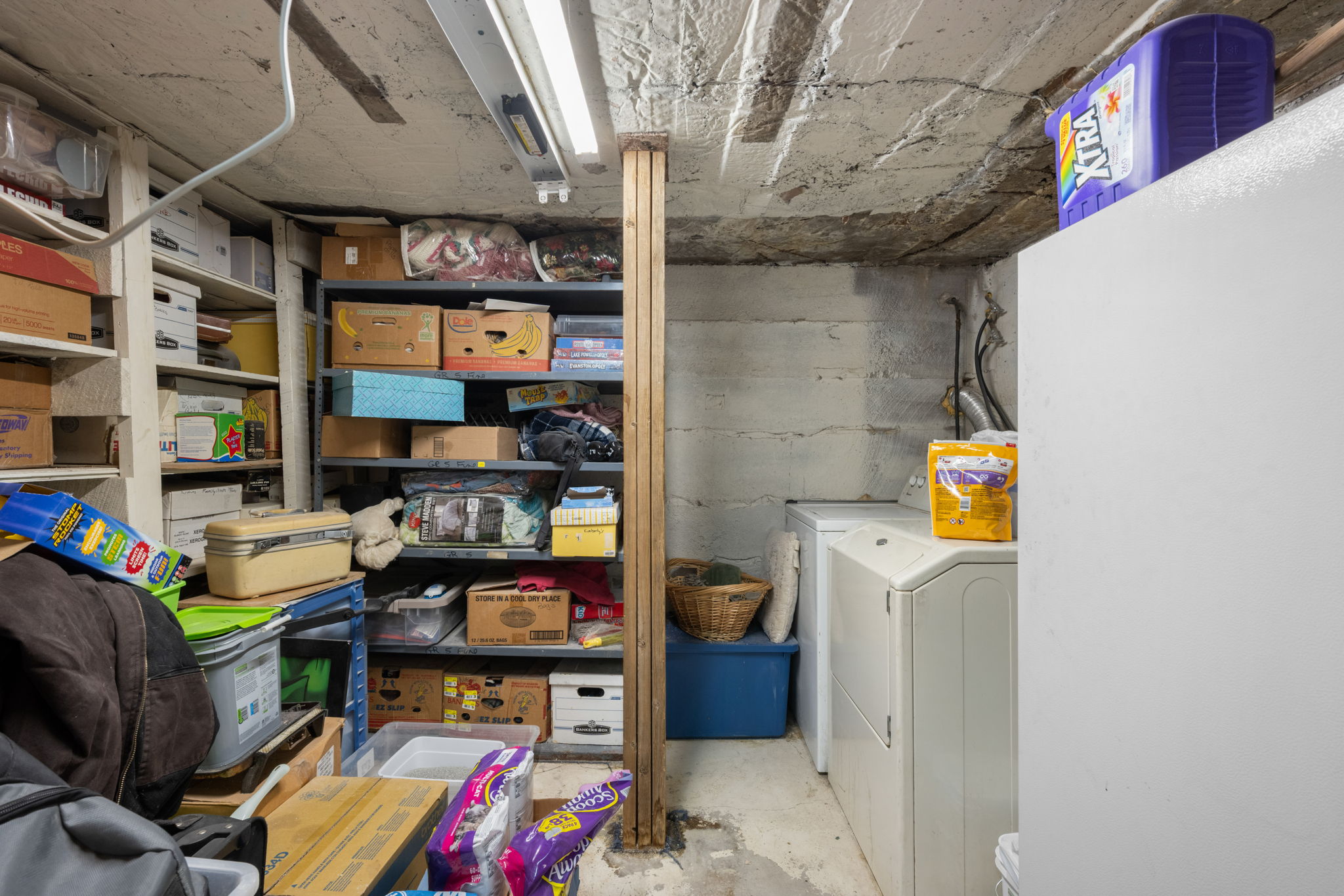 Basement storage area featuring exposed concrete walls and ceiling