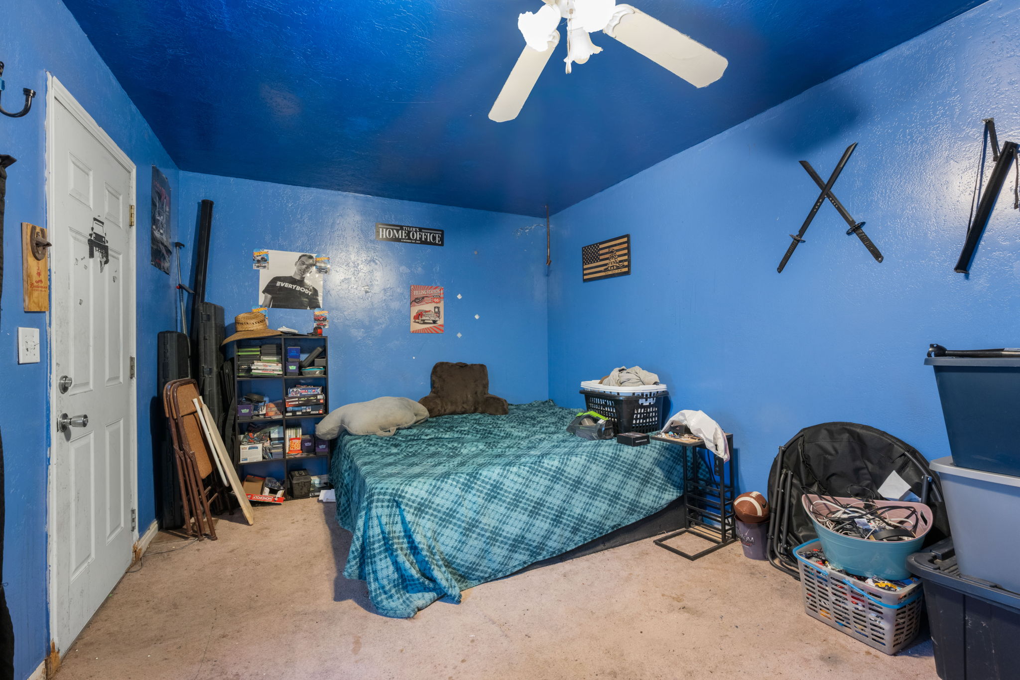 Interior space featuring blue walls and ceiling, a white paneled door, and a white ceiling fan