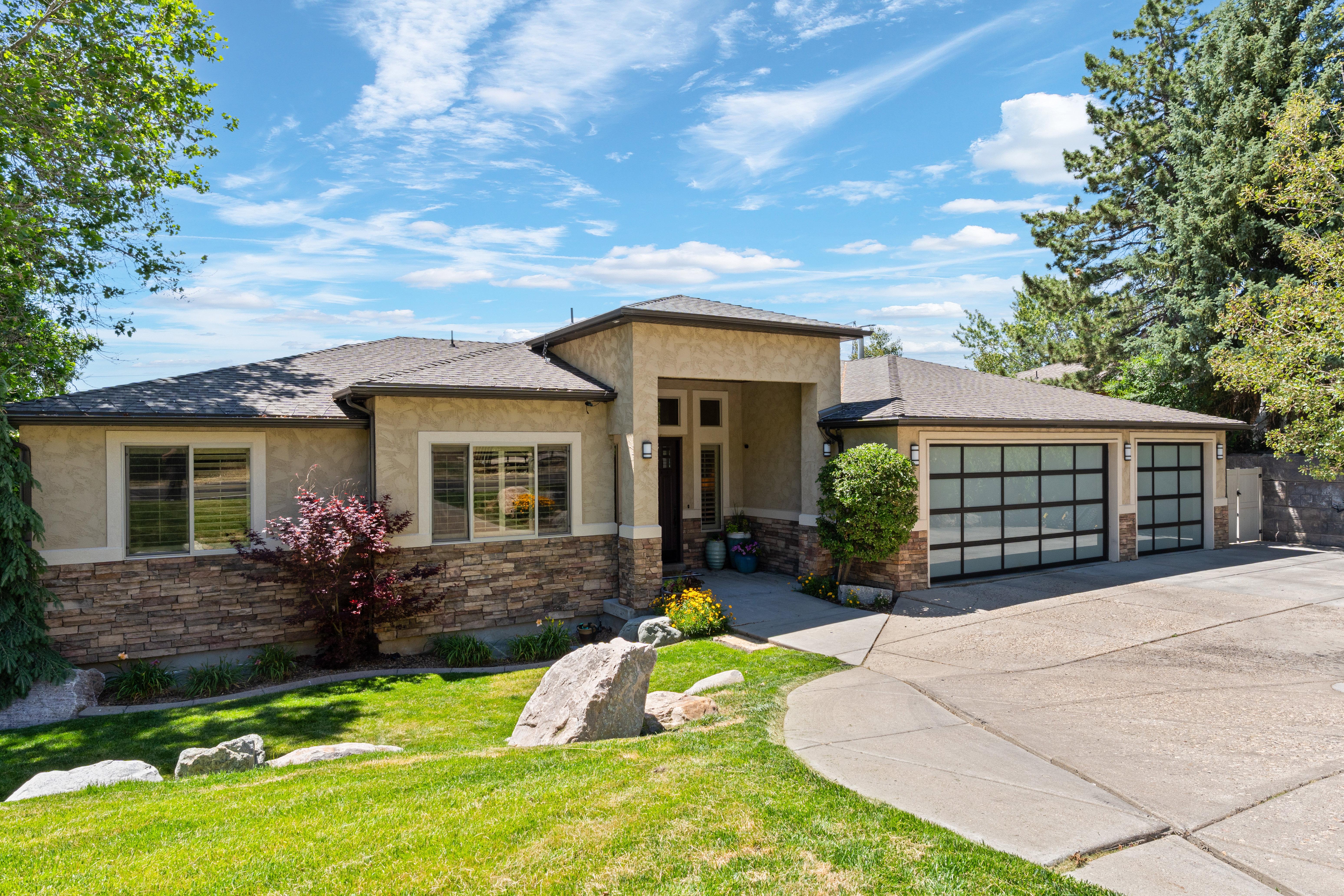 Contemporary stucco residence featuring a stone veneer facade