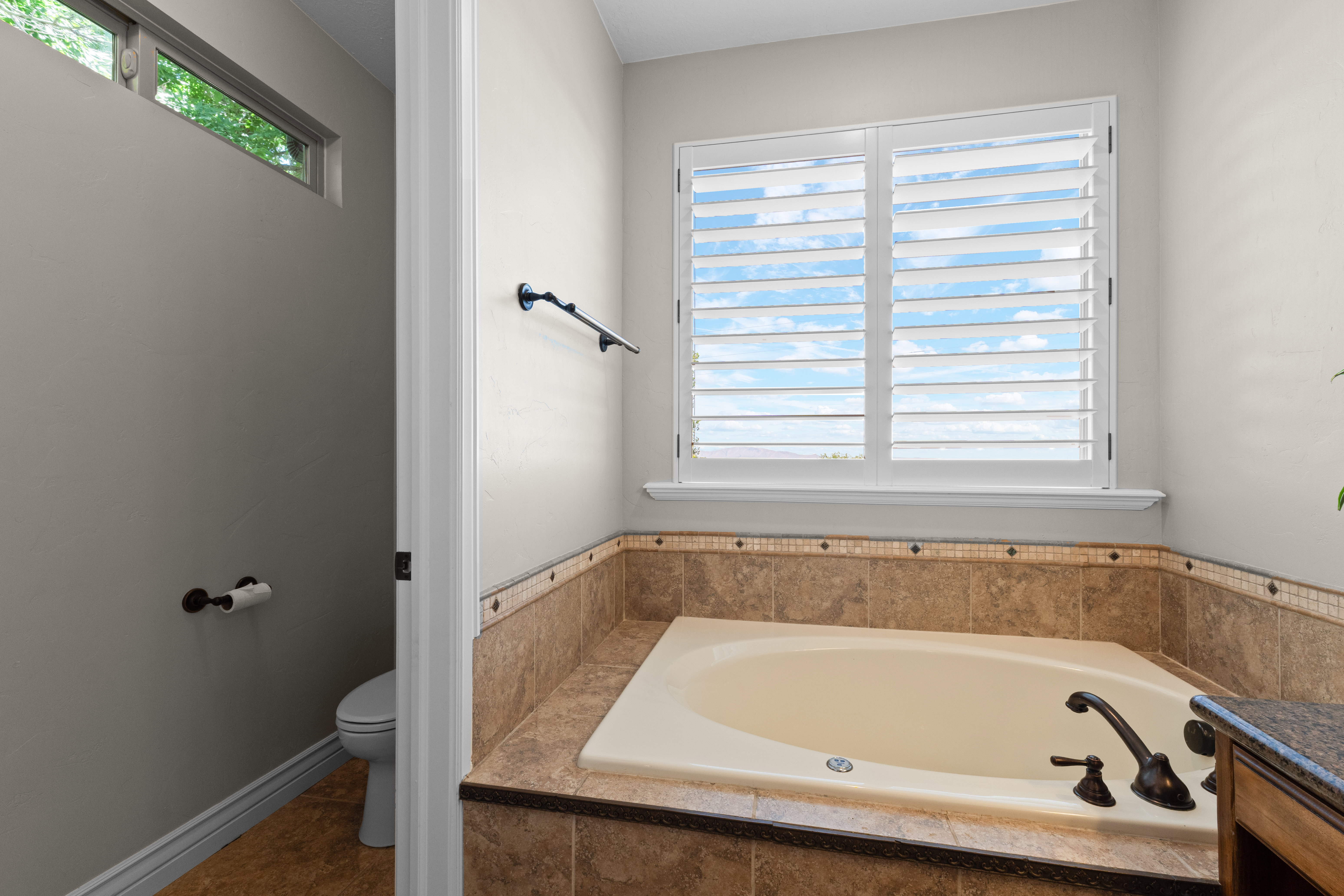 Built-in soaking tub with tile surround and oil-rubbed bronze fixtures