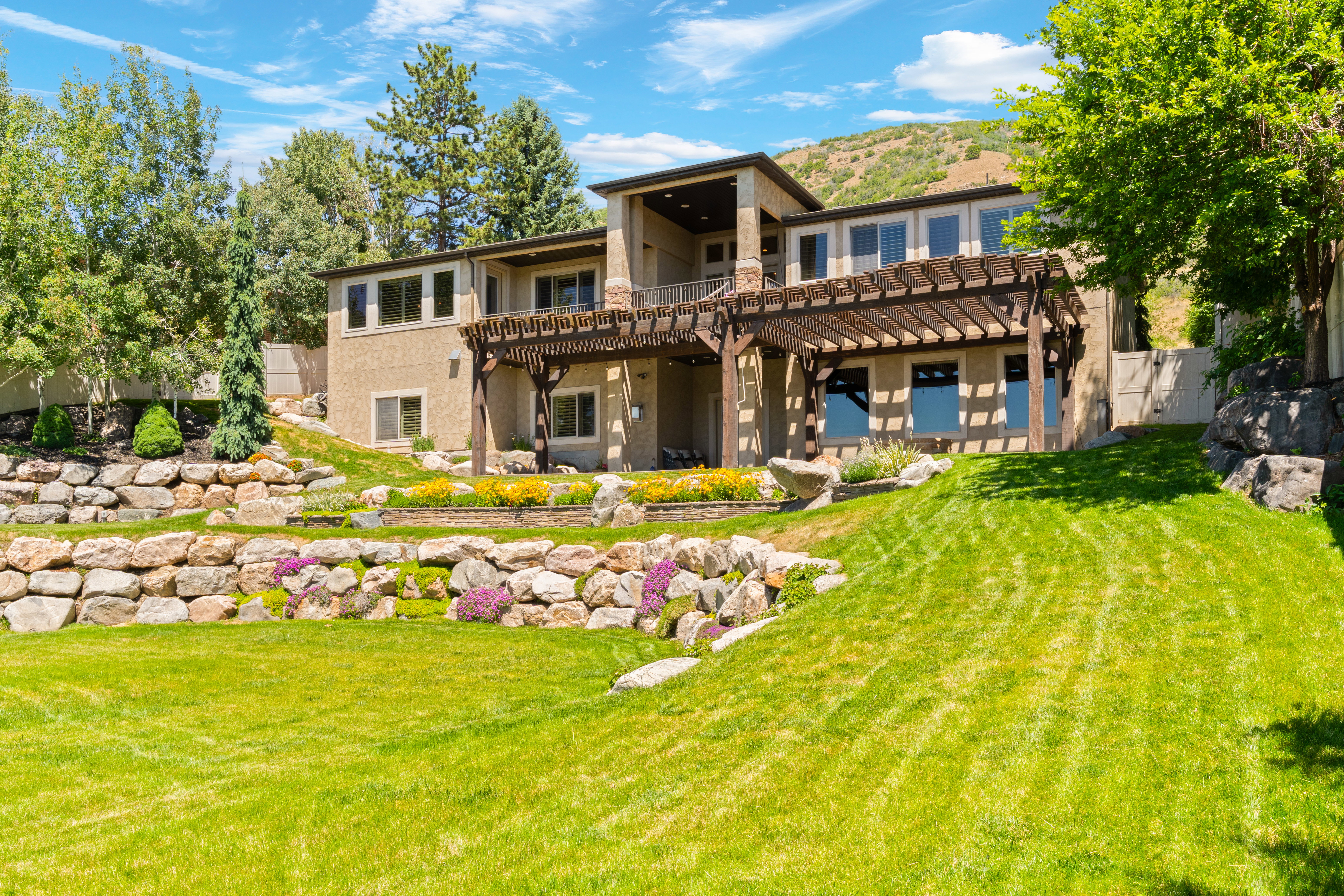 Terraced landscaping featuring natural stone retaining walls and vibrant plantings