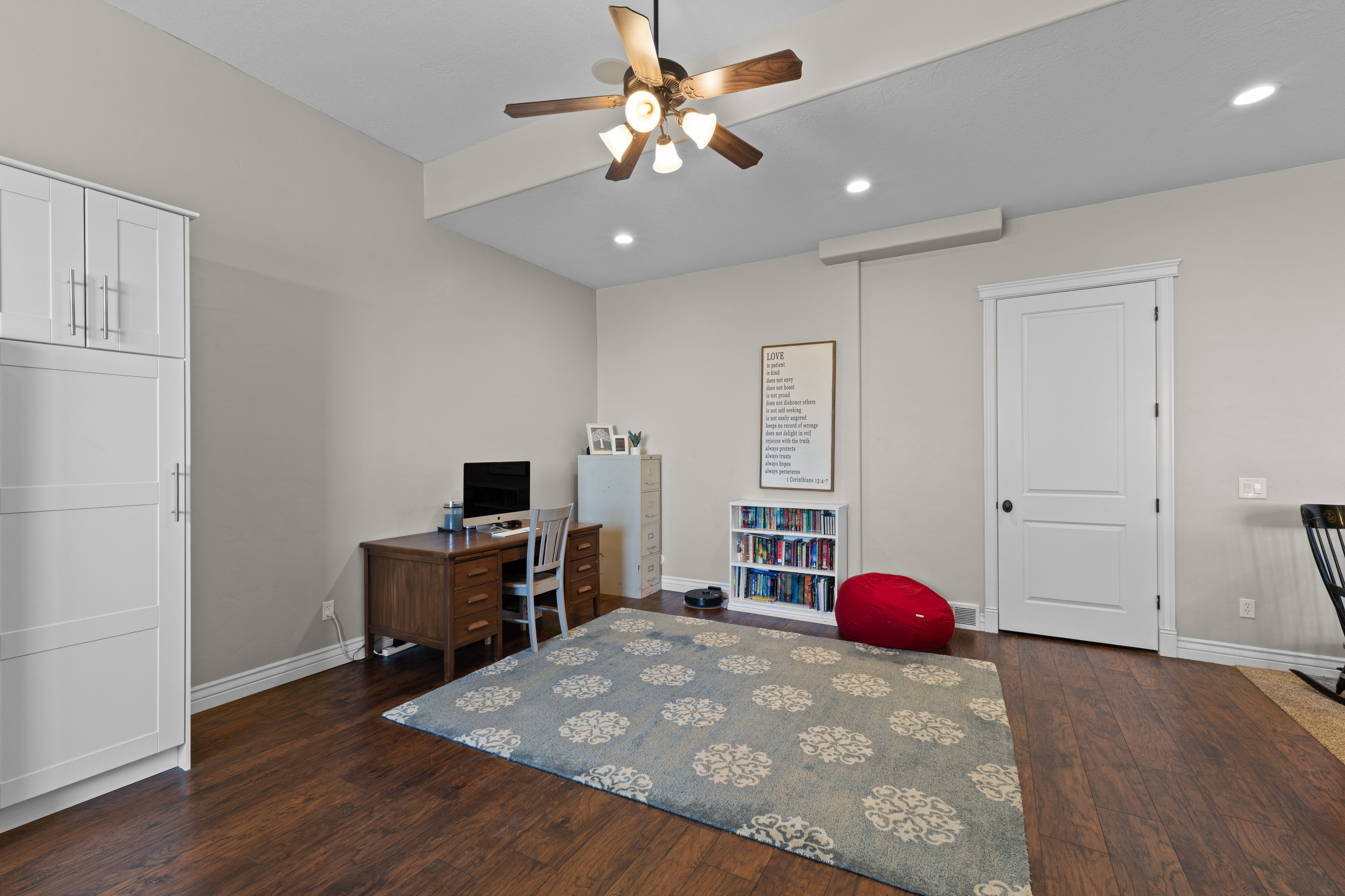 Spacious room featuring wood-finish flooring, light gray wall tones, and recessed lighting