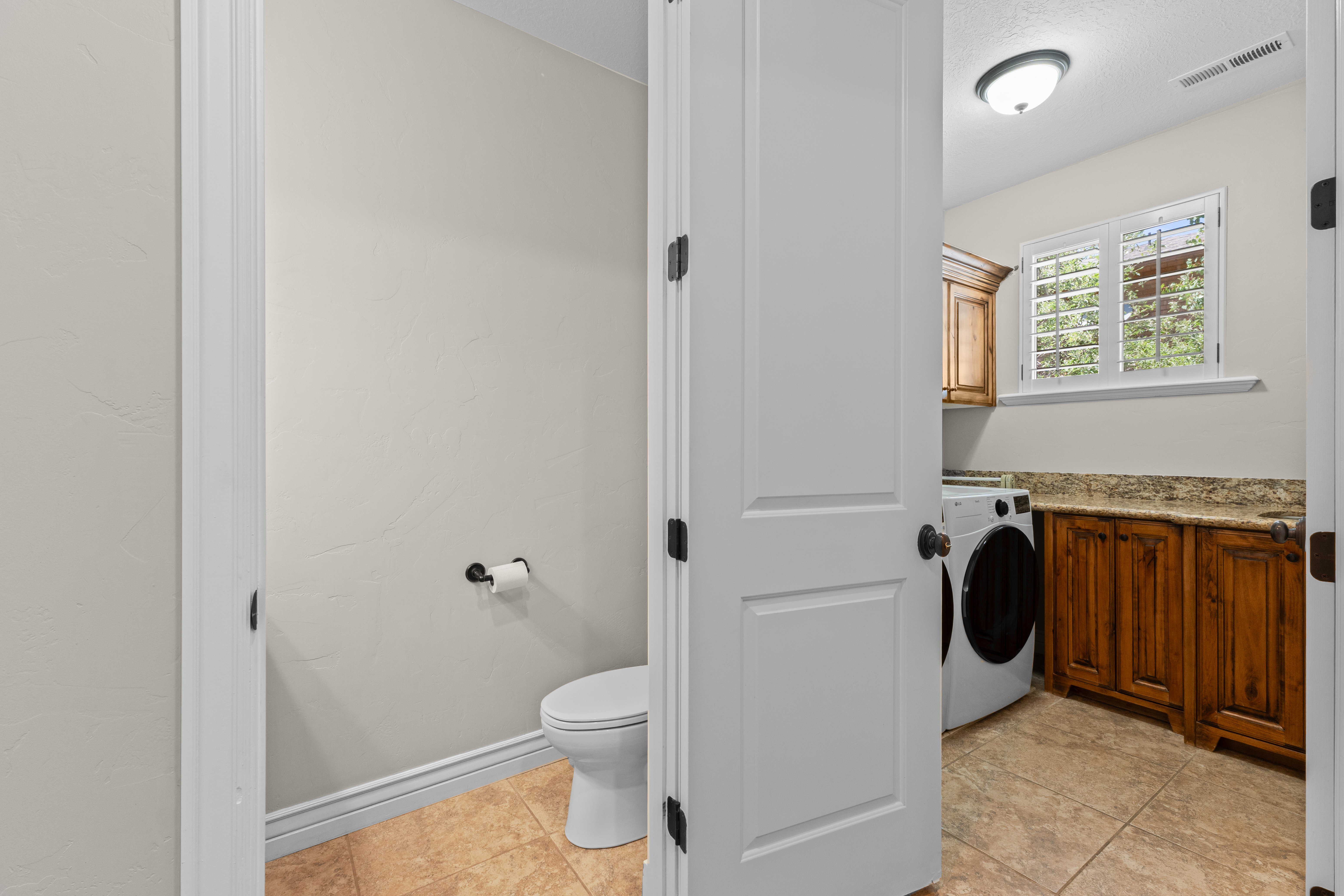 Powder room with a toilet and tile flooring