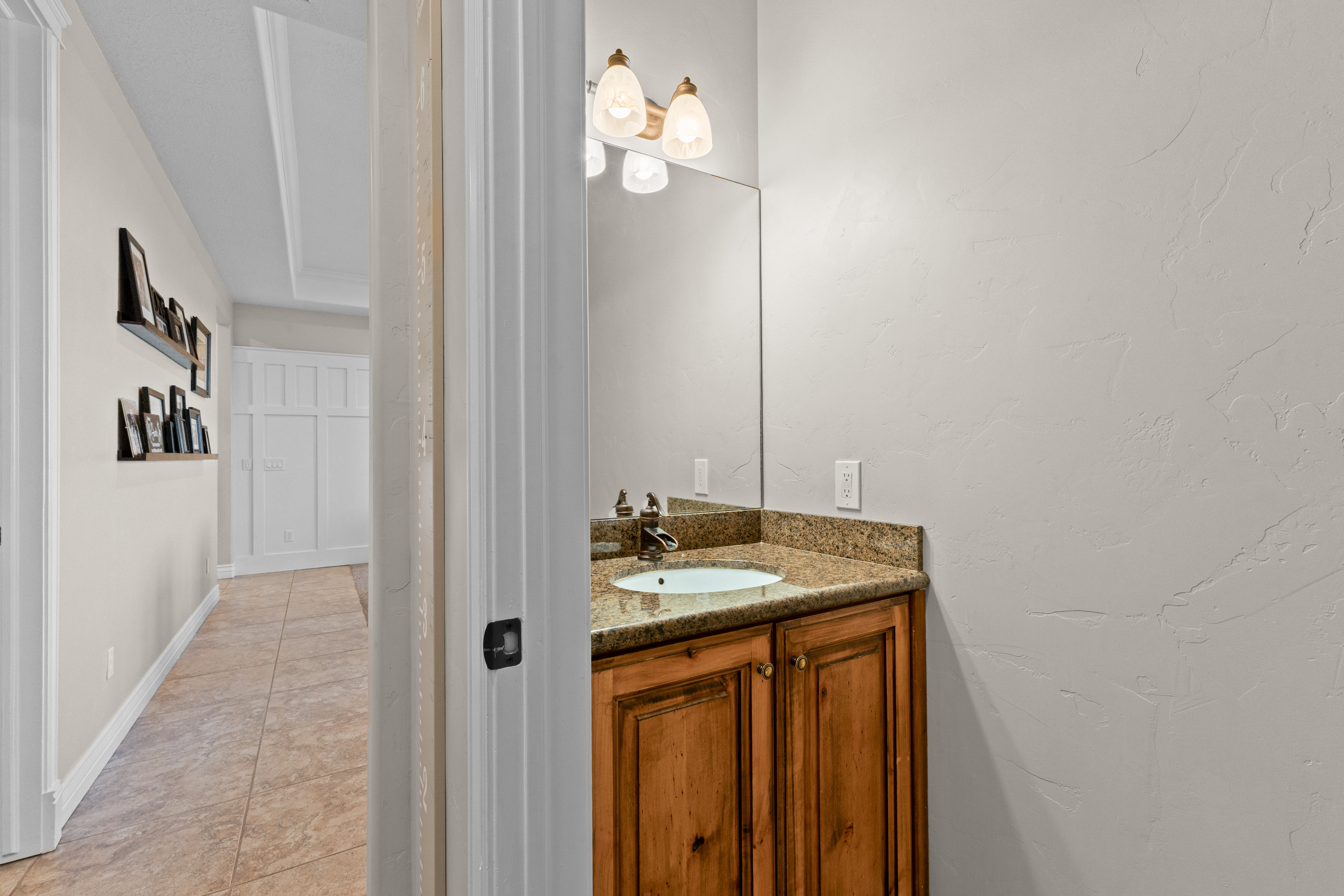 Wood-finish vanity with a stone-finish countertop and an undermount sink