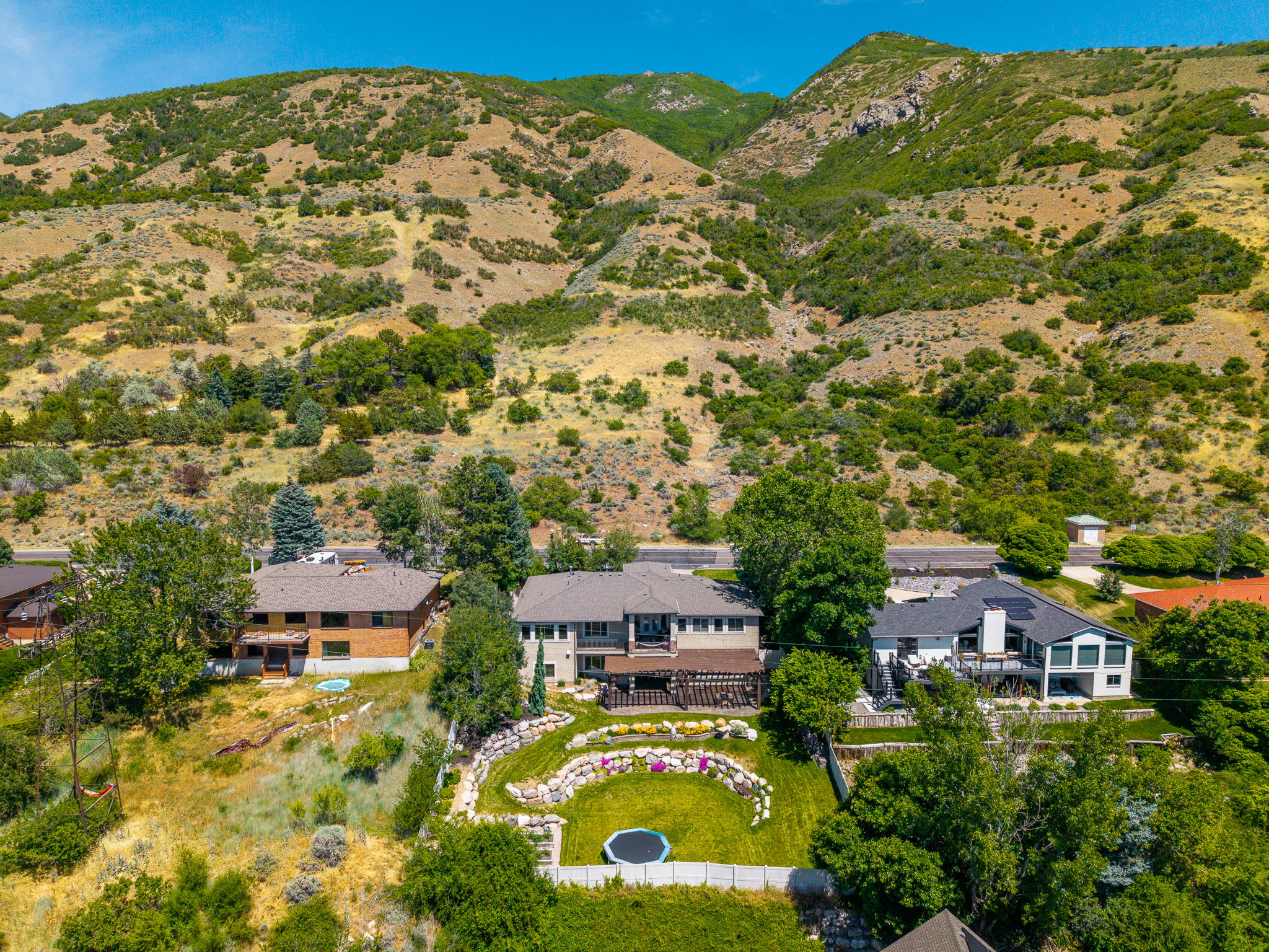 Expansive outdoor living area featuring a terraced lawn, a retaining wall with planting beds, and a lower-level grass area