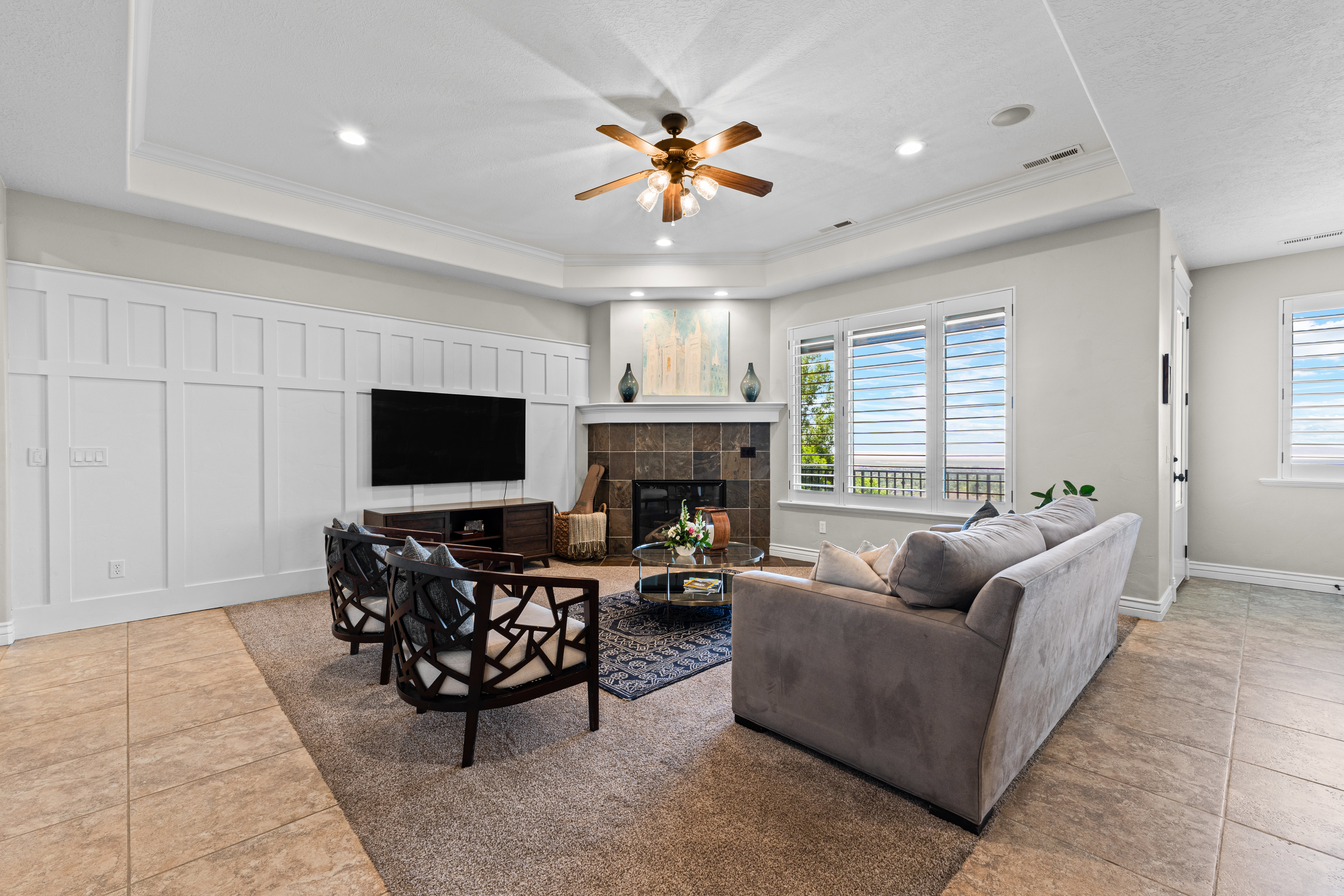 Spacious living area featuring a tray ceiling, recessed lighting, and a ceiling fan