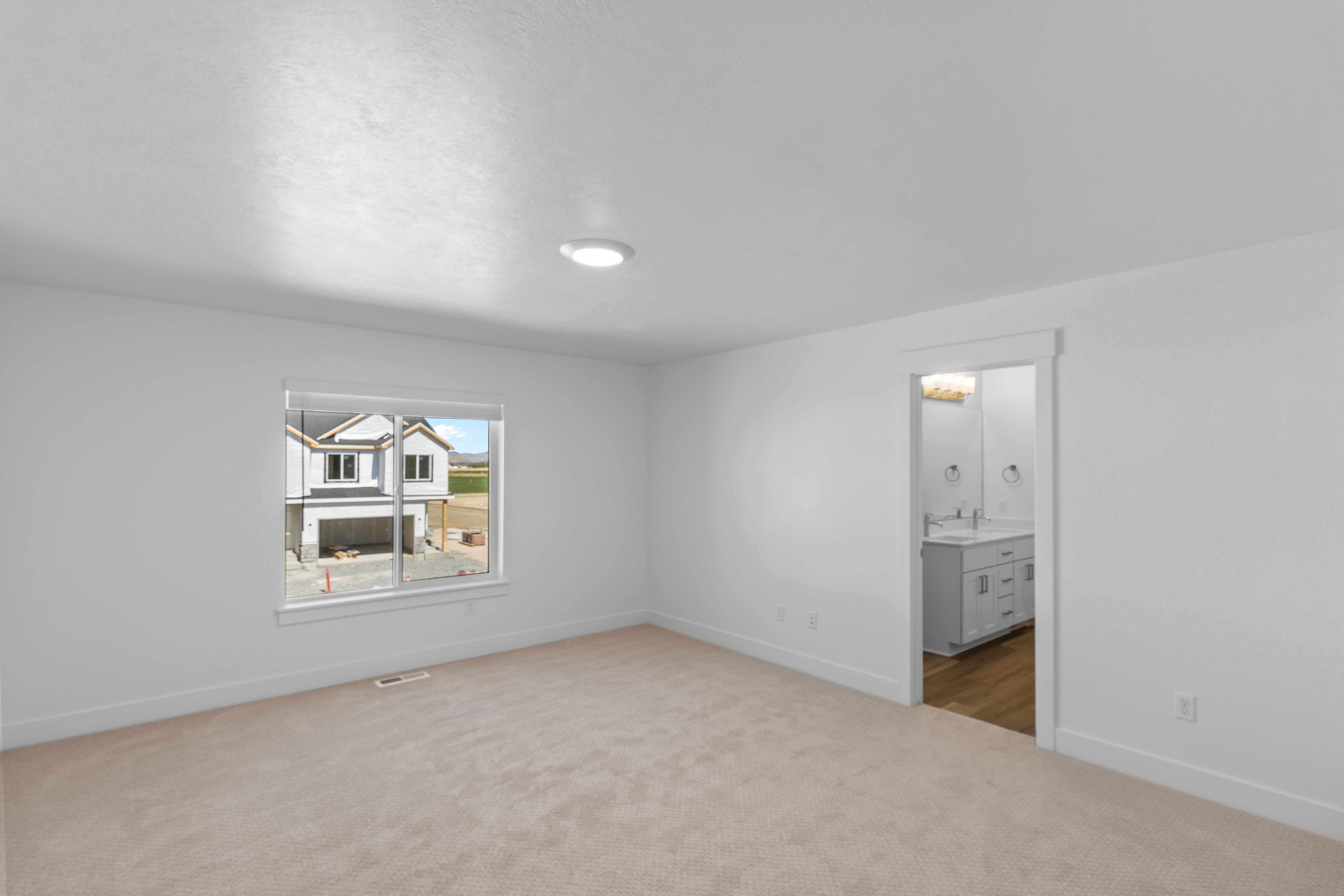 Carpeted room with white walls, a recessed ceiling light, and a window featuring white trim