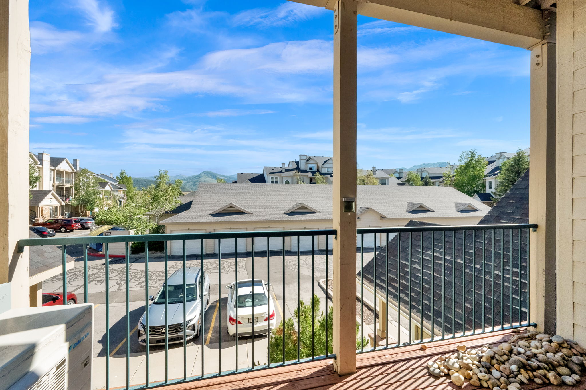 Expansive balcony featuring wood-finish flooring, a metal railing, and broad landscape views