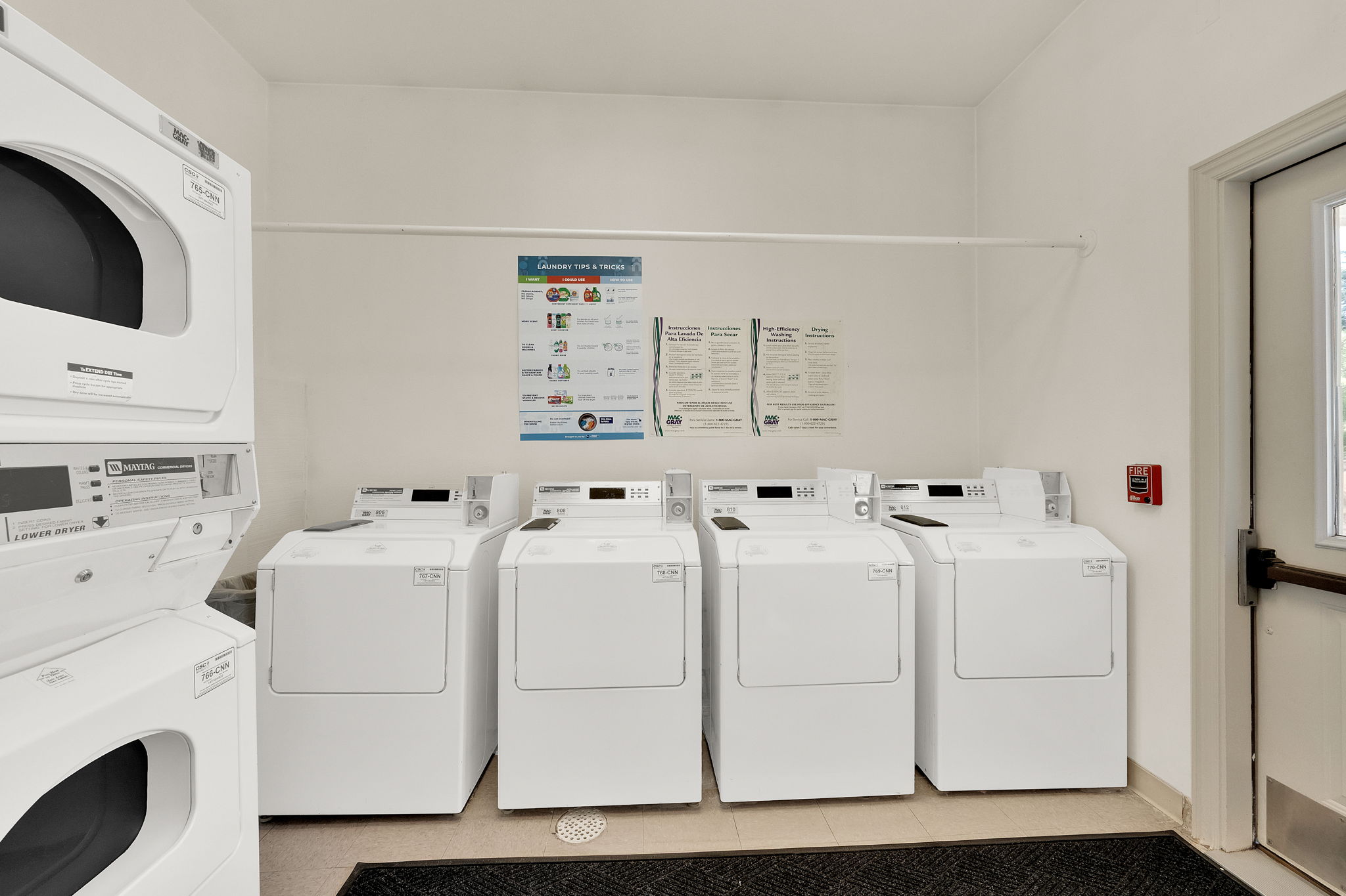 Dedicated laundry facility featuring multiple front-loading washing machines and stacked dryers