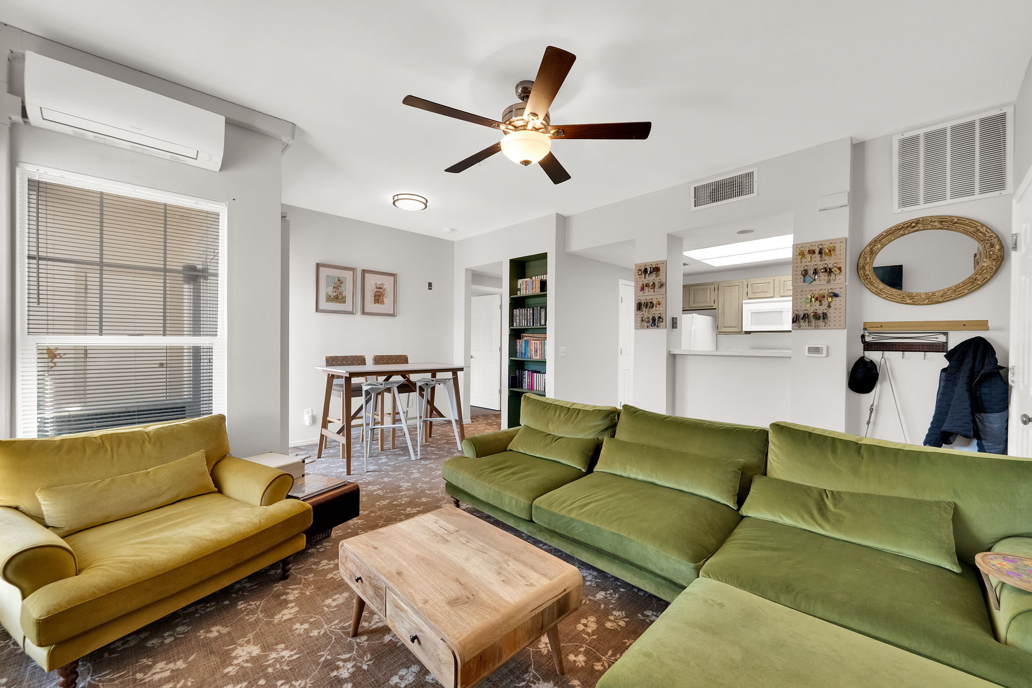 Open-concept living space featuring patterned carpeting and a ceiling fan
