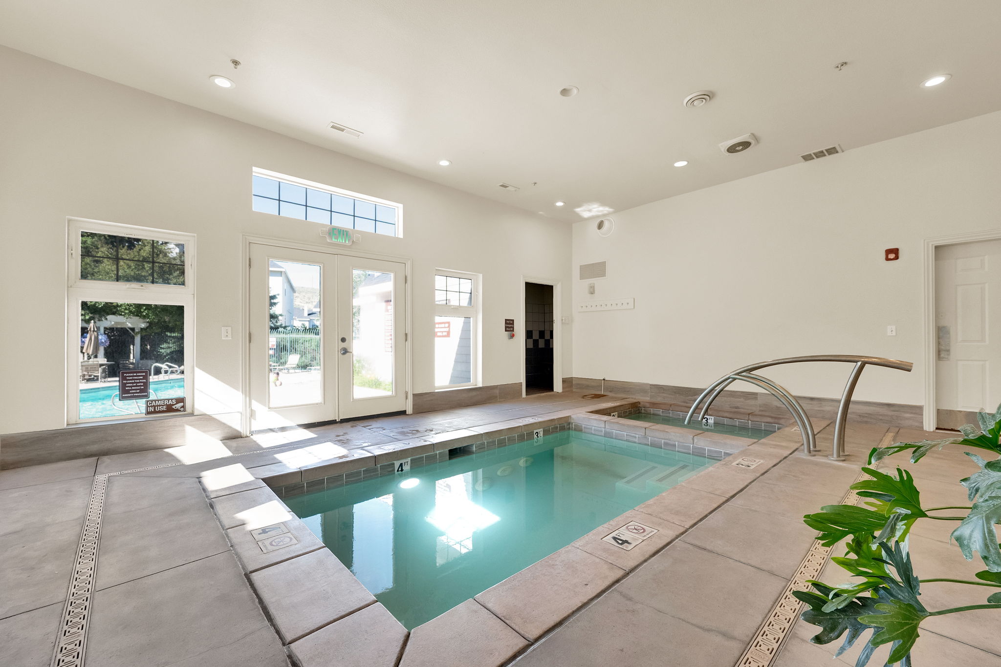 Indoor swimming pool and spa area featuring concrete tile surround