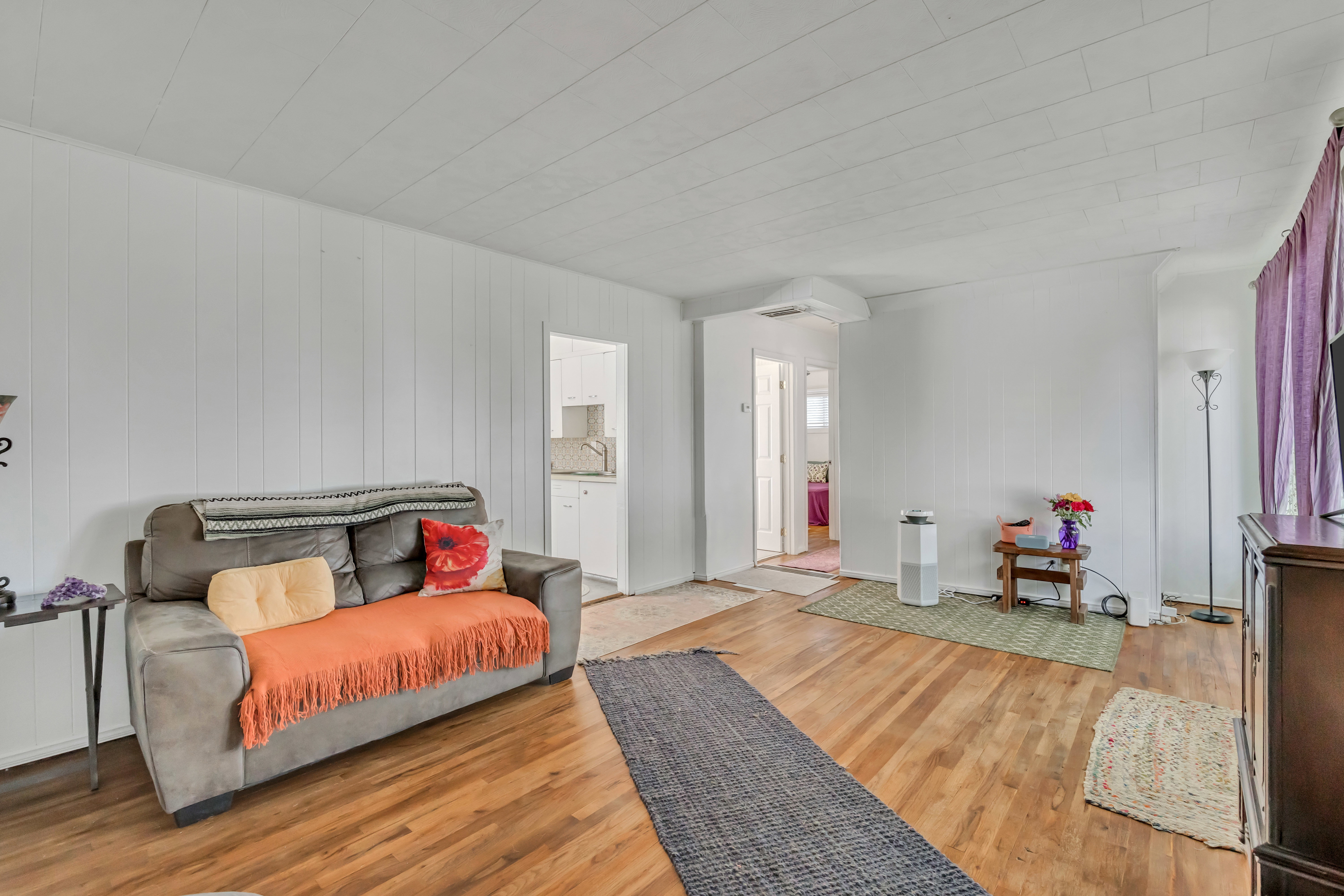 Open-concept living area featuring wood-finish flooring and white vertical paneling