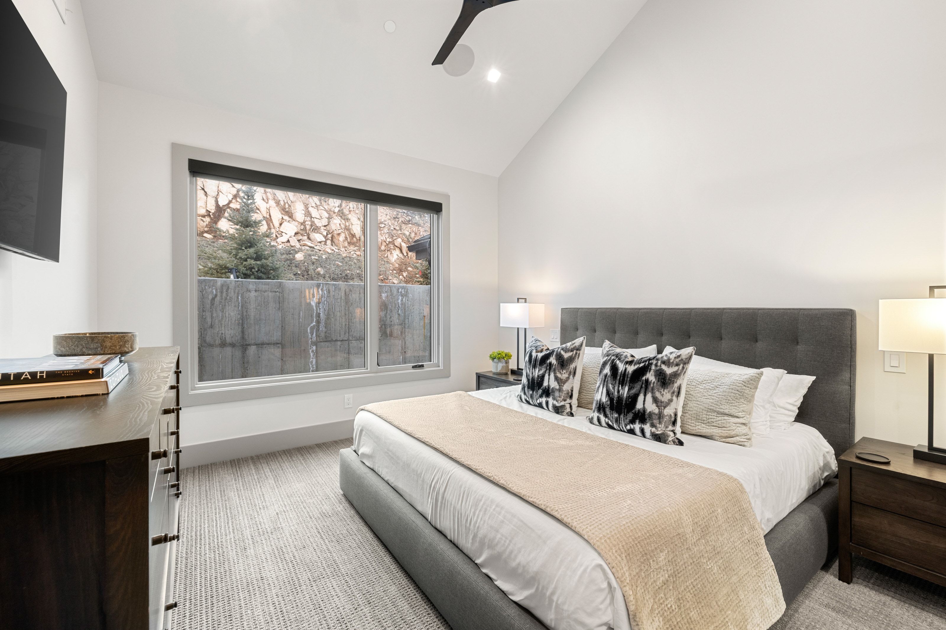 Vaulted ceiling bedroom with a large window, recessed lighting, and a contemporary ceiling fan