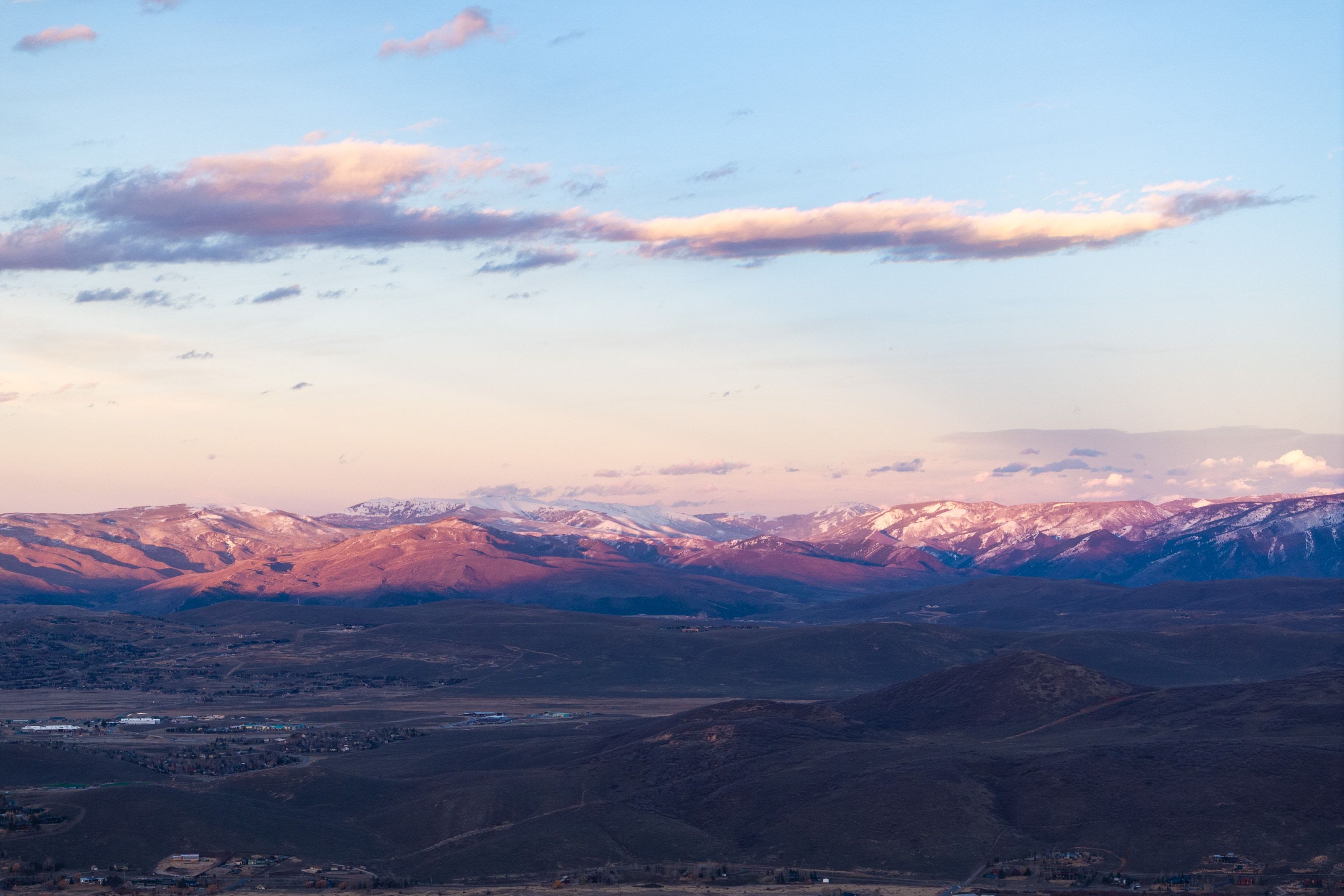 Expansive mountain range featuring snow-capped peaks and a broad valley