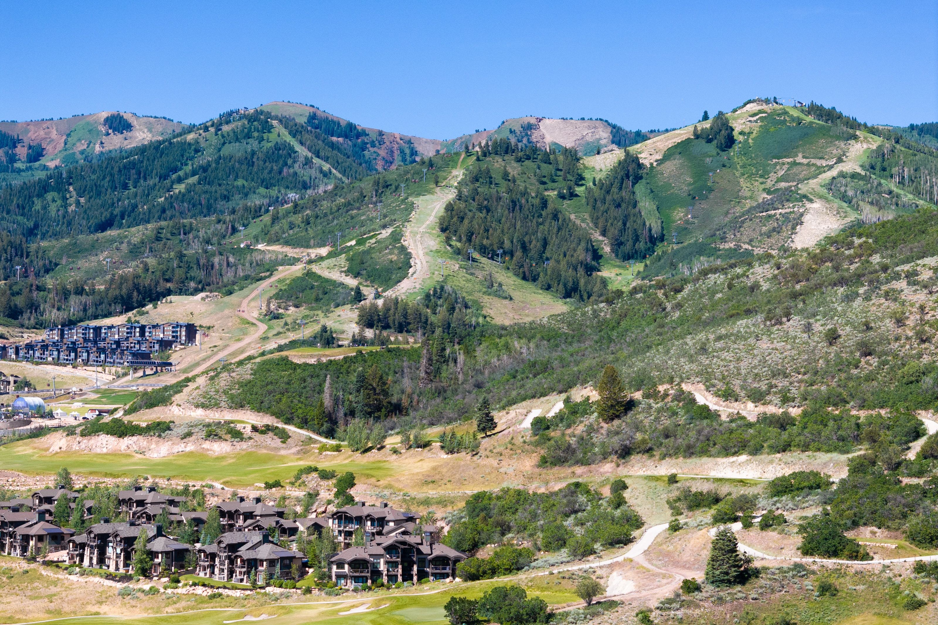 Mountain landscape featuring ski runs, evergreen forests, and multiple residential developments