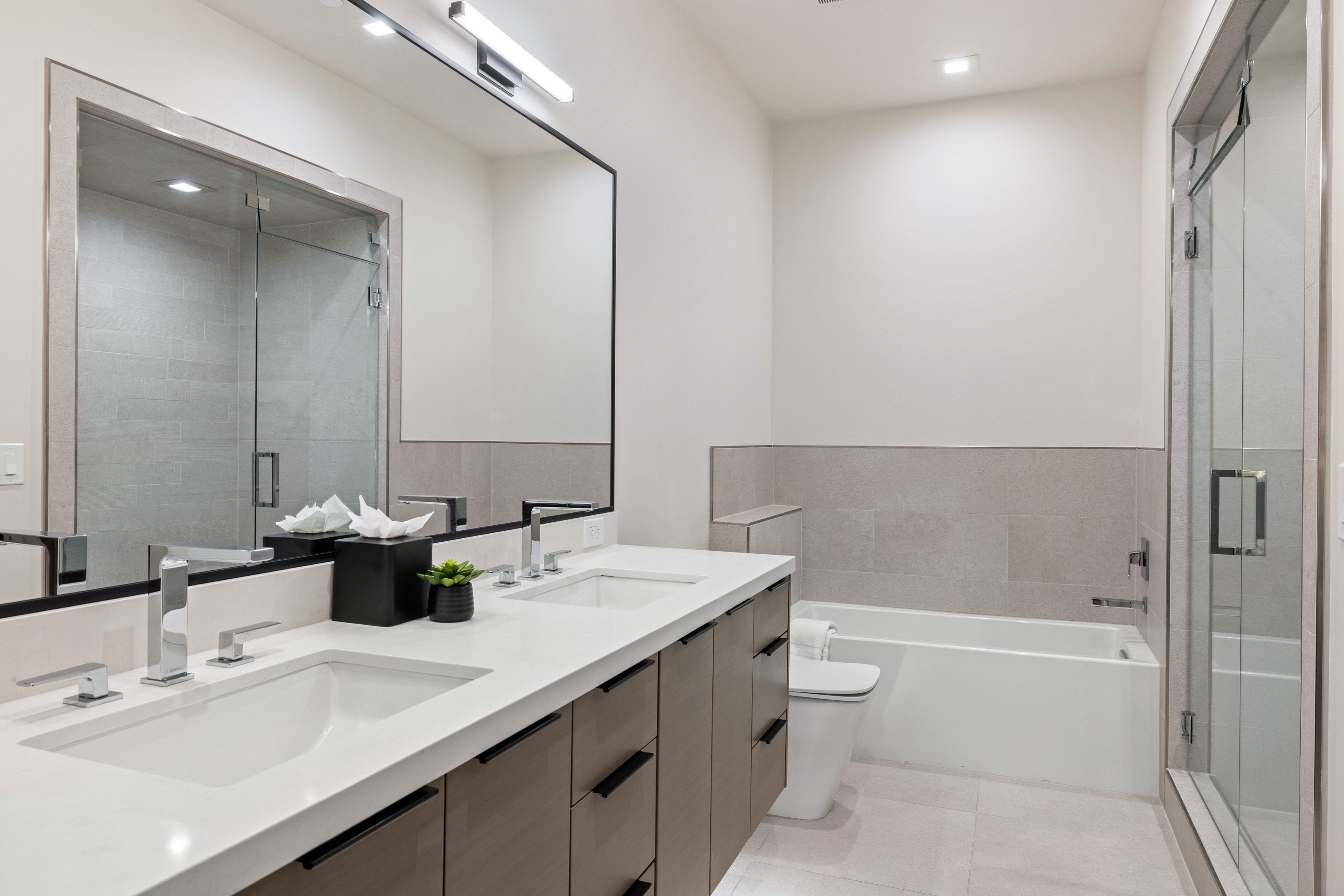 Double vanity with under-mount sinks, chrome fixtures, and a white countertop