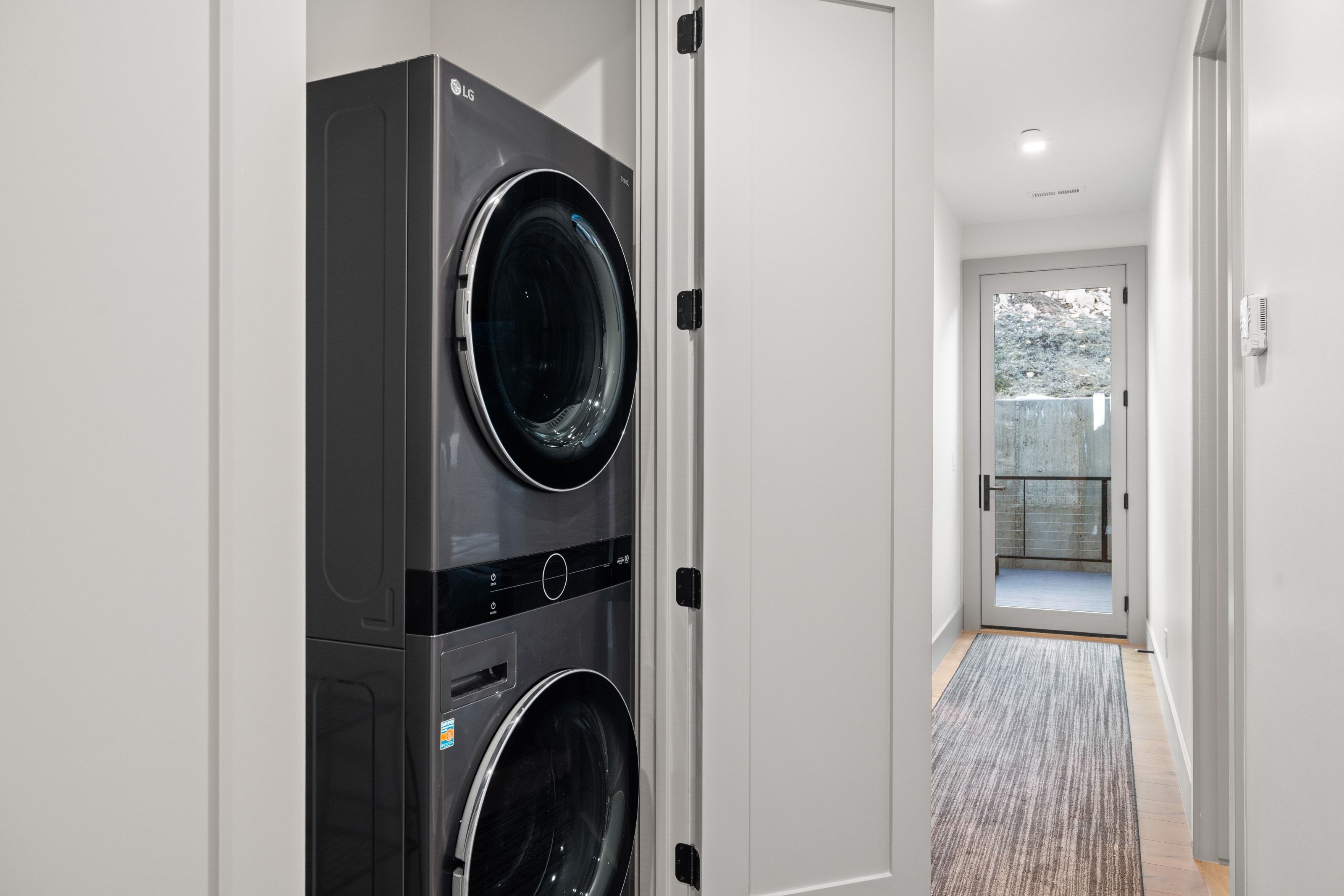 Laundry closet featuring a stacked washer and dryer unit