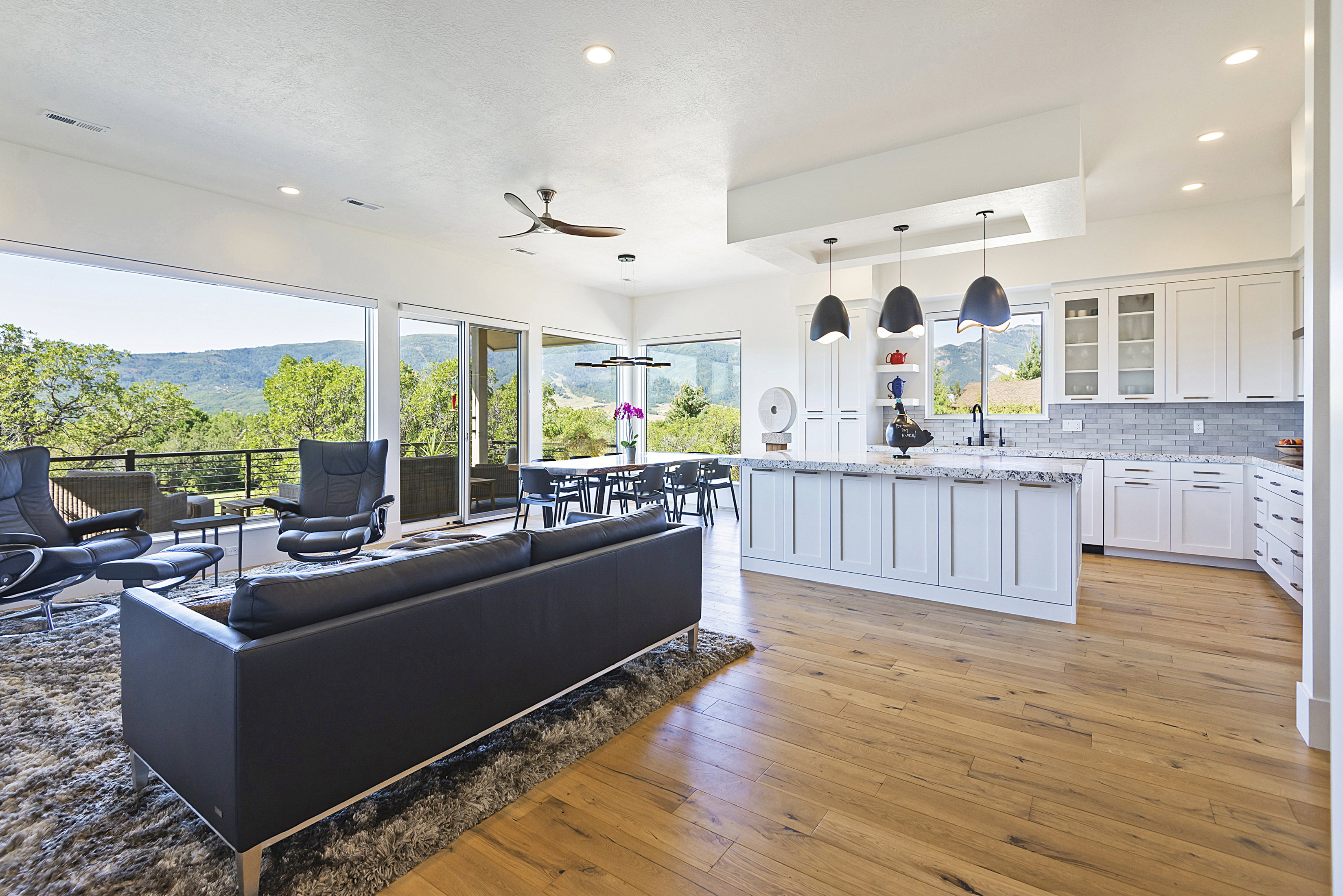 Expansive open-concept living space with wood-finish flooring