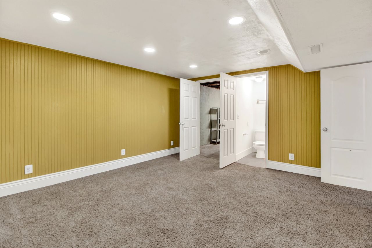 Basement bedroom features on door leading to laundry room and the other door leading to bathroom.
