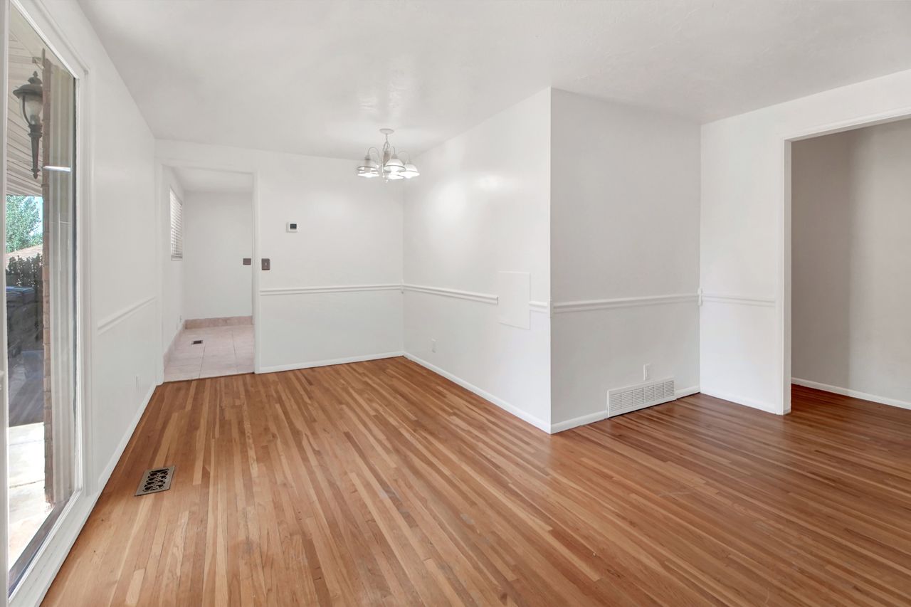 Spacious room featuring wood-finish flooring, and  white walls.