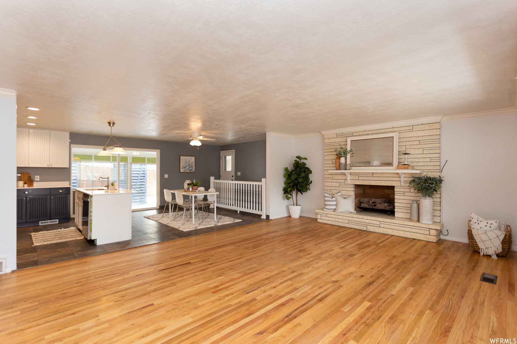 Hardwood flooring throughout the main living area, complemented by a stacked stone fireplace