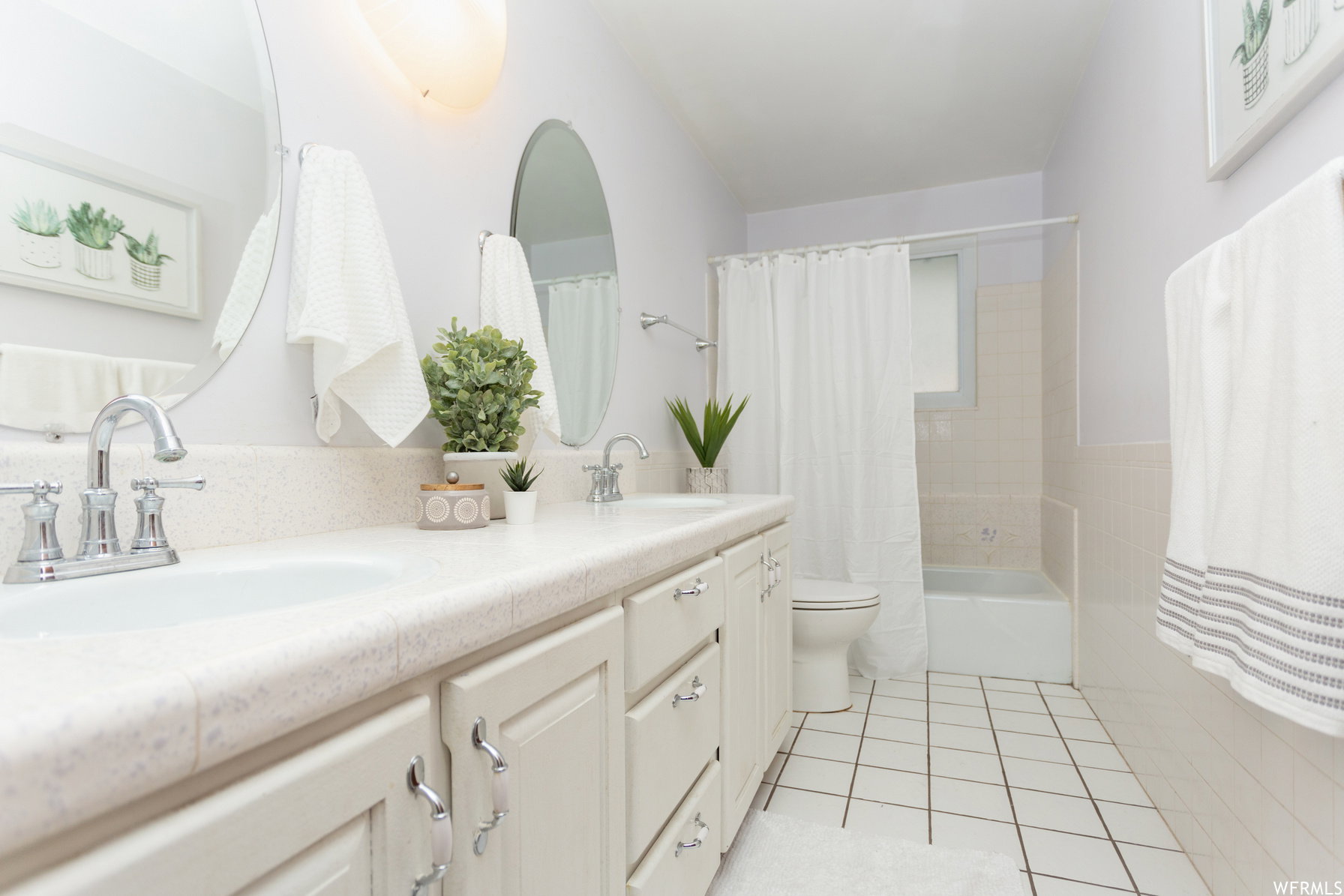 Double vanity with integrated sinks, chrome faucets, and an oval mirror