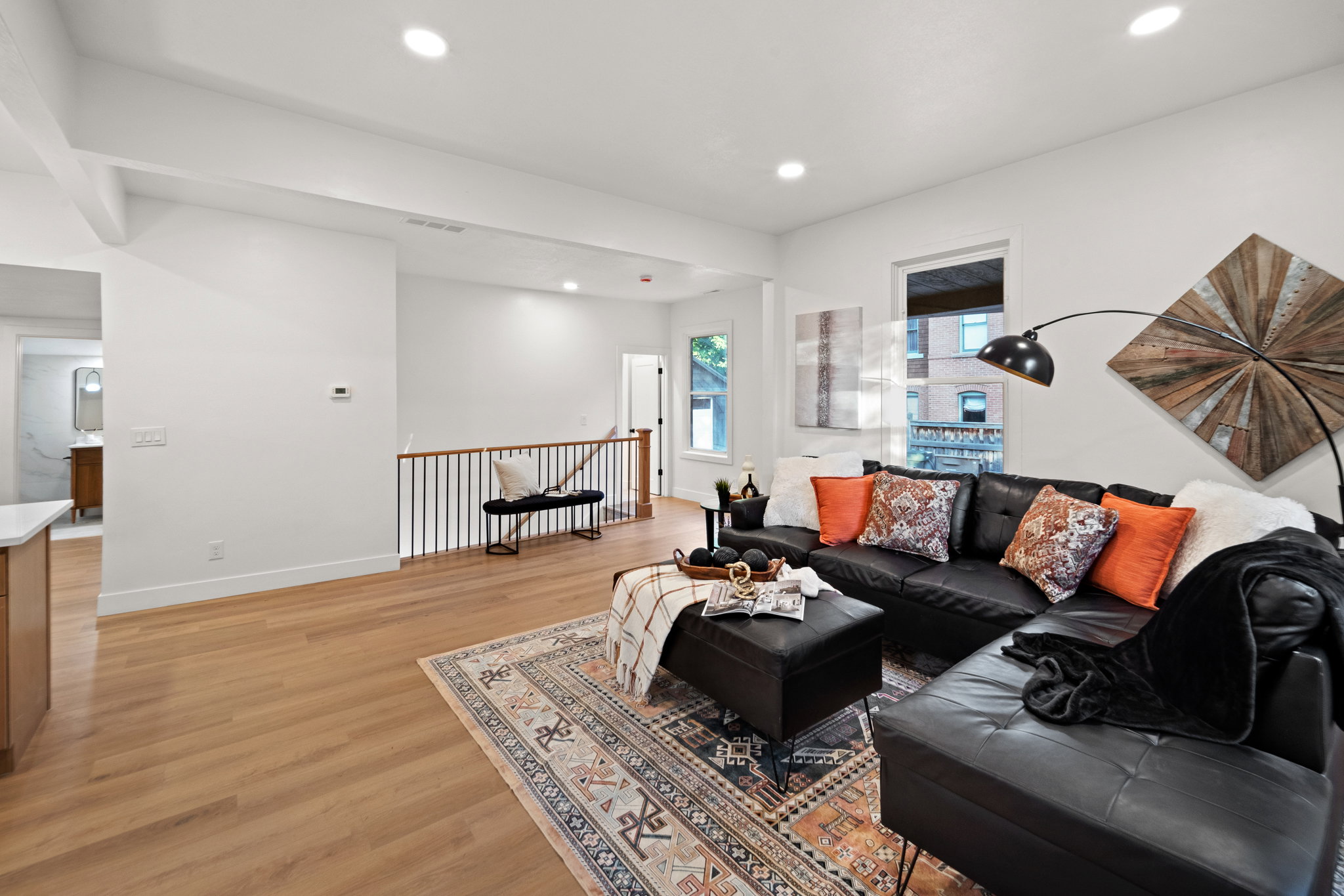 Open-concept living area featuring wood-finish flooring, recessed lighting, and a white color palette