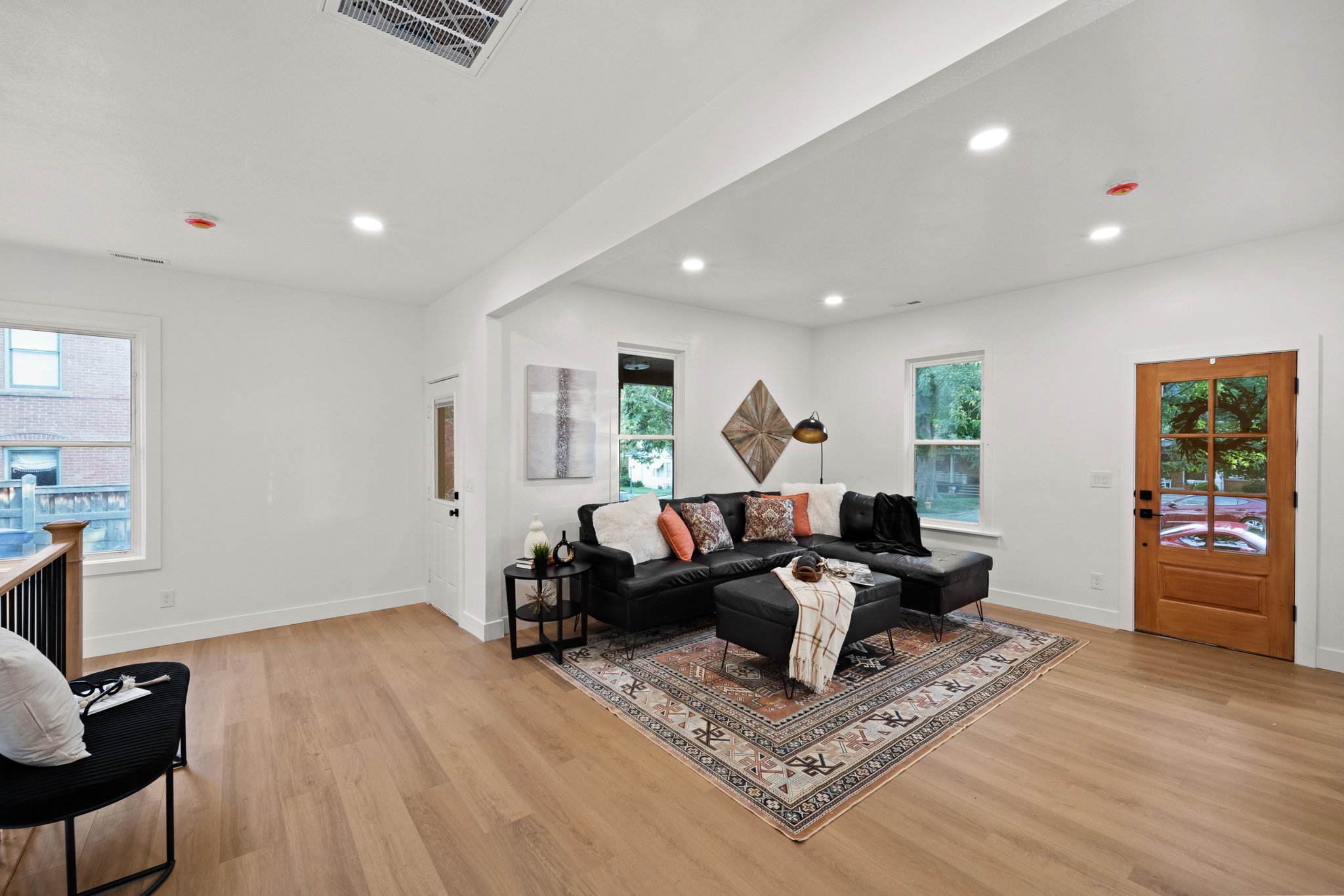 Open-concept living area featuring light wood-finish flooring, recessed lighting, and white walls