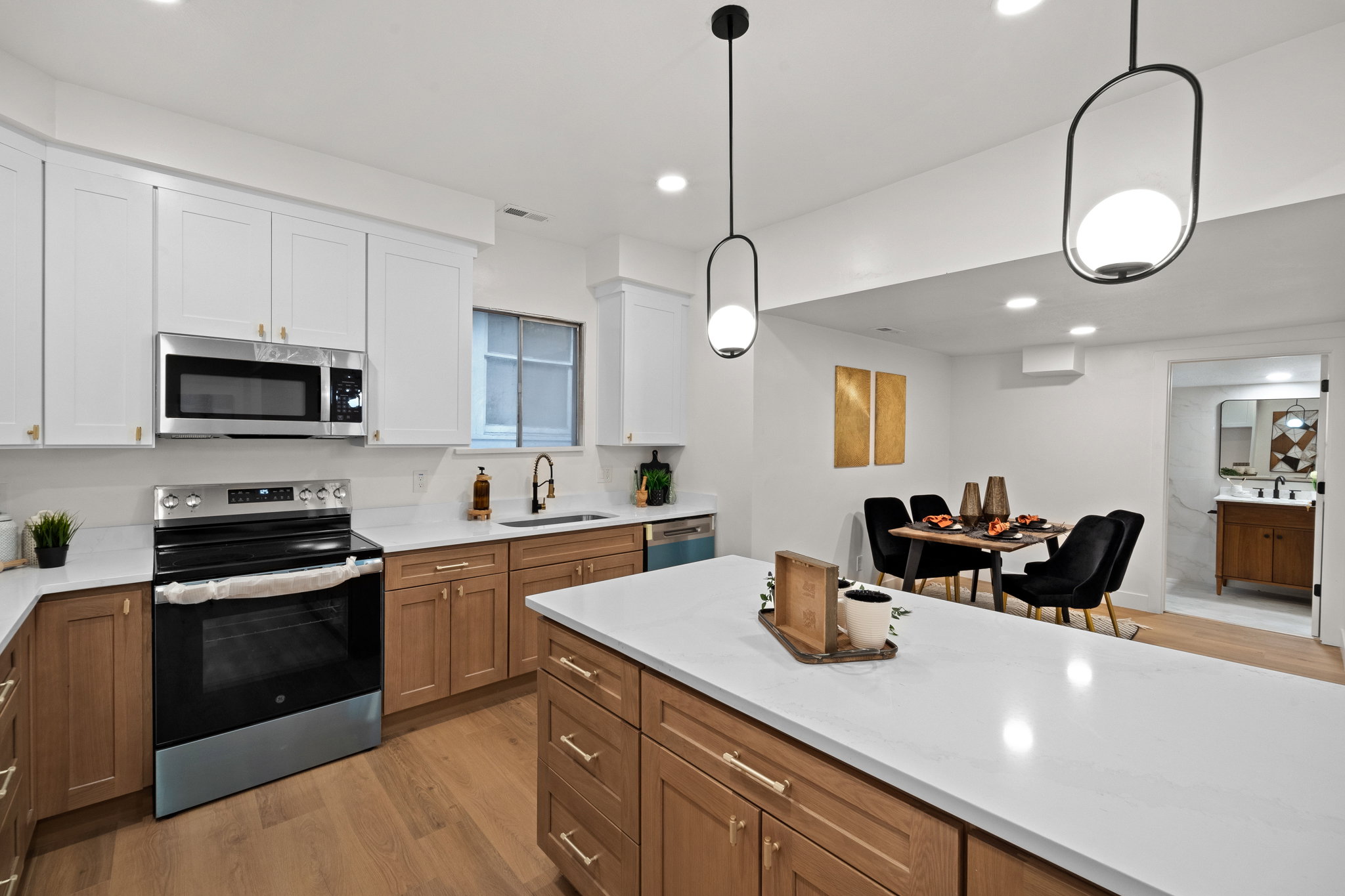 Modern kitchen featuring white upper cabinetry, wood-finish lower cabinetry, and stainless steel appliances