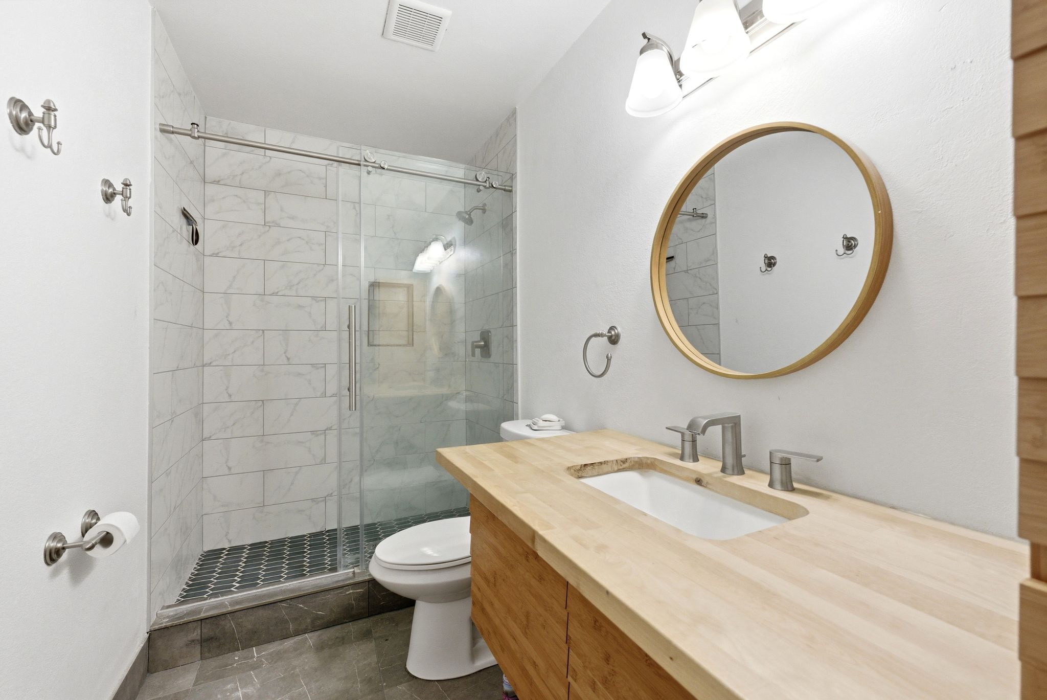Bathroom featuring a wood-finish vanity with integrated rectangular sink and brushed nickel fixtures