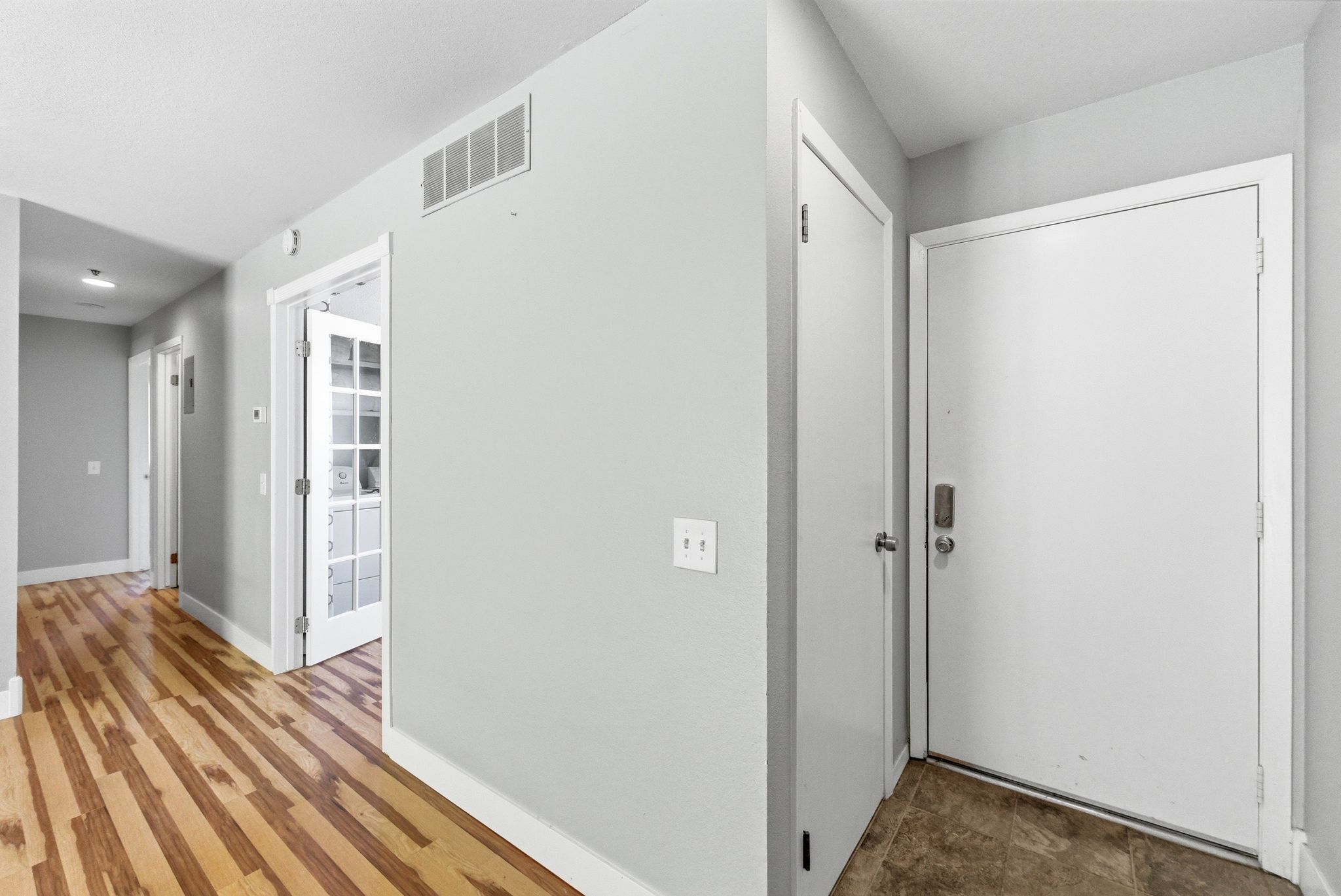 Entryway featuring a white door, tile flooring, and light gray walls