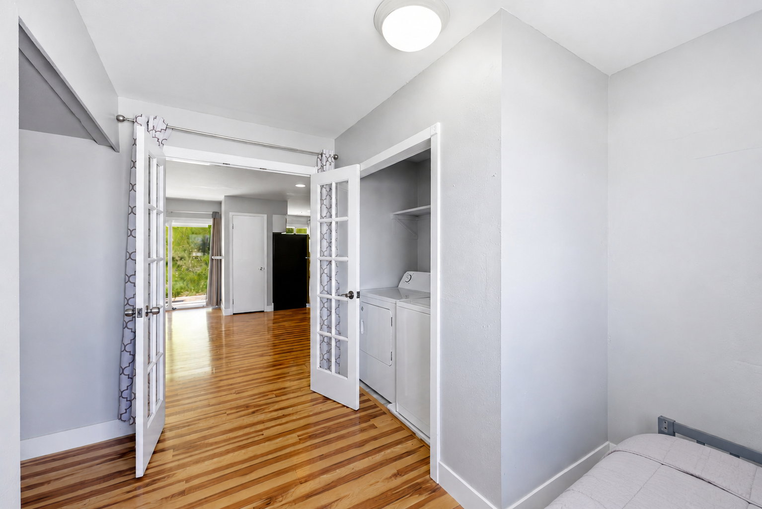 Interior space featuring wood-finish flooring, light gray wall paint, and white trim