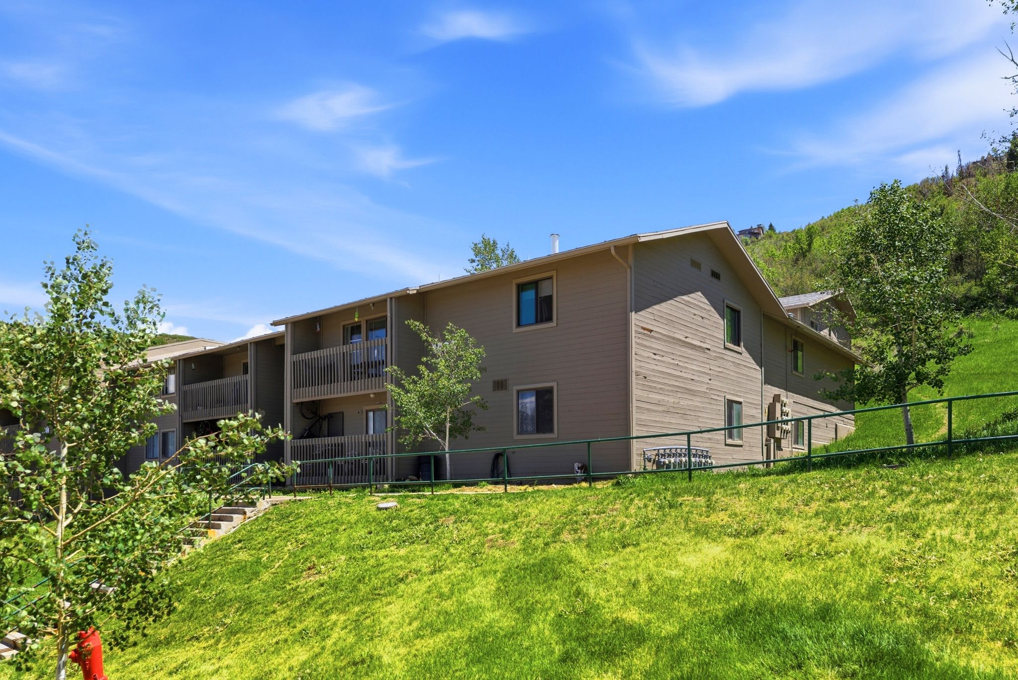 Multi-story building featuring tan horizontal siding and gabled rooflines