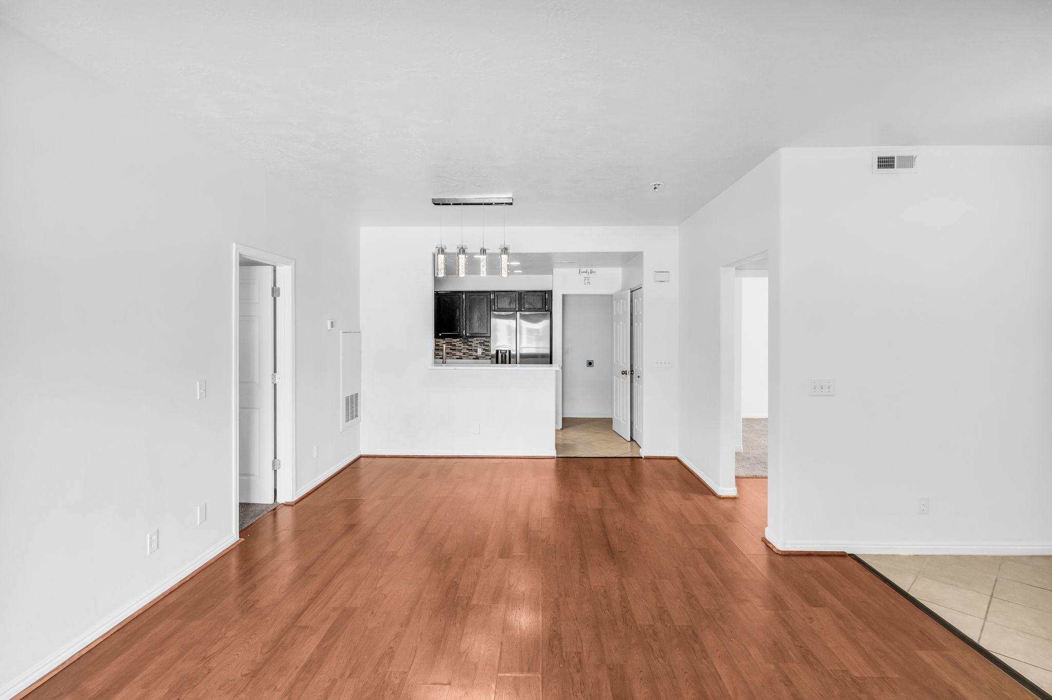 Open living area featuring wood-finish flooring, white walls, and recessed lighting