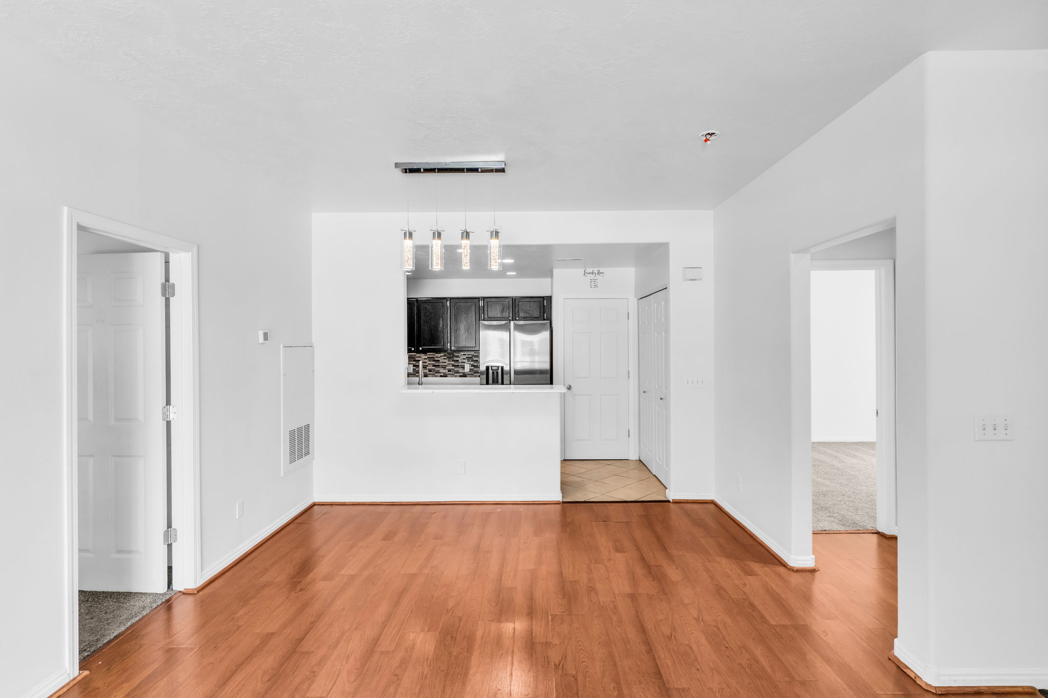 Open concept living space featuring wood-finish flooring, white walls, and recessed lighting