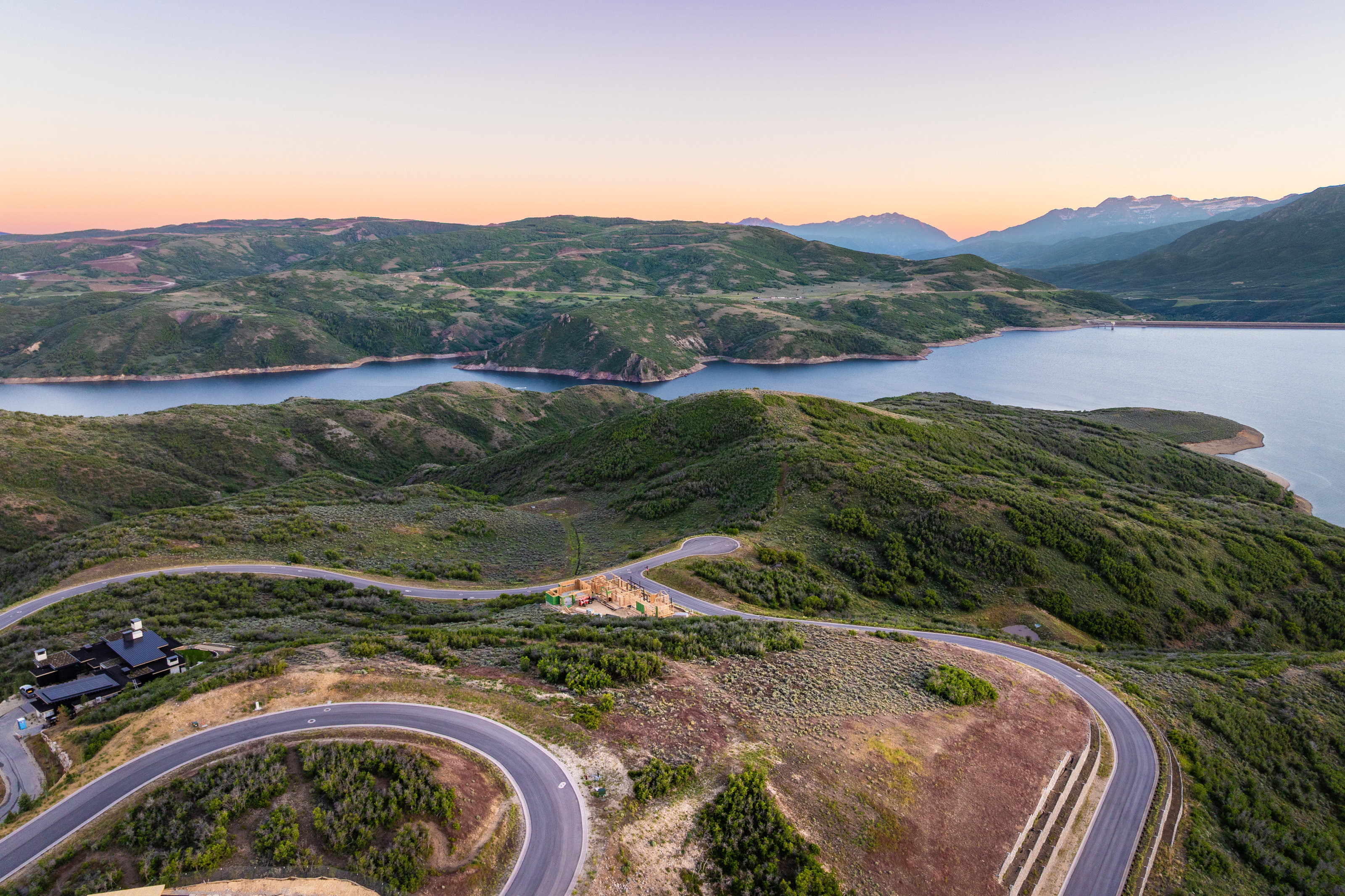 Expansive hillsides featuring a prominent lake and distant mountains