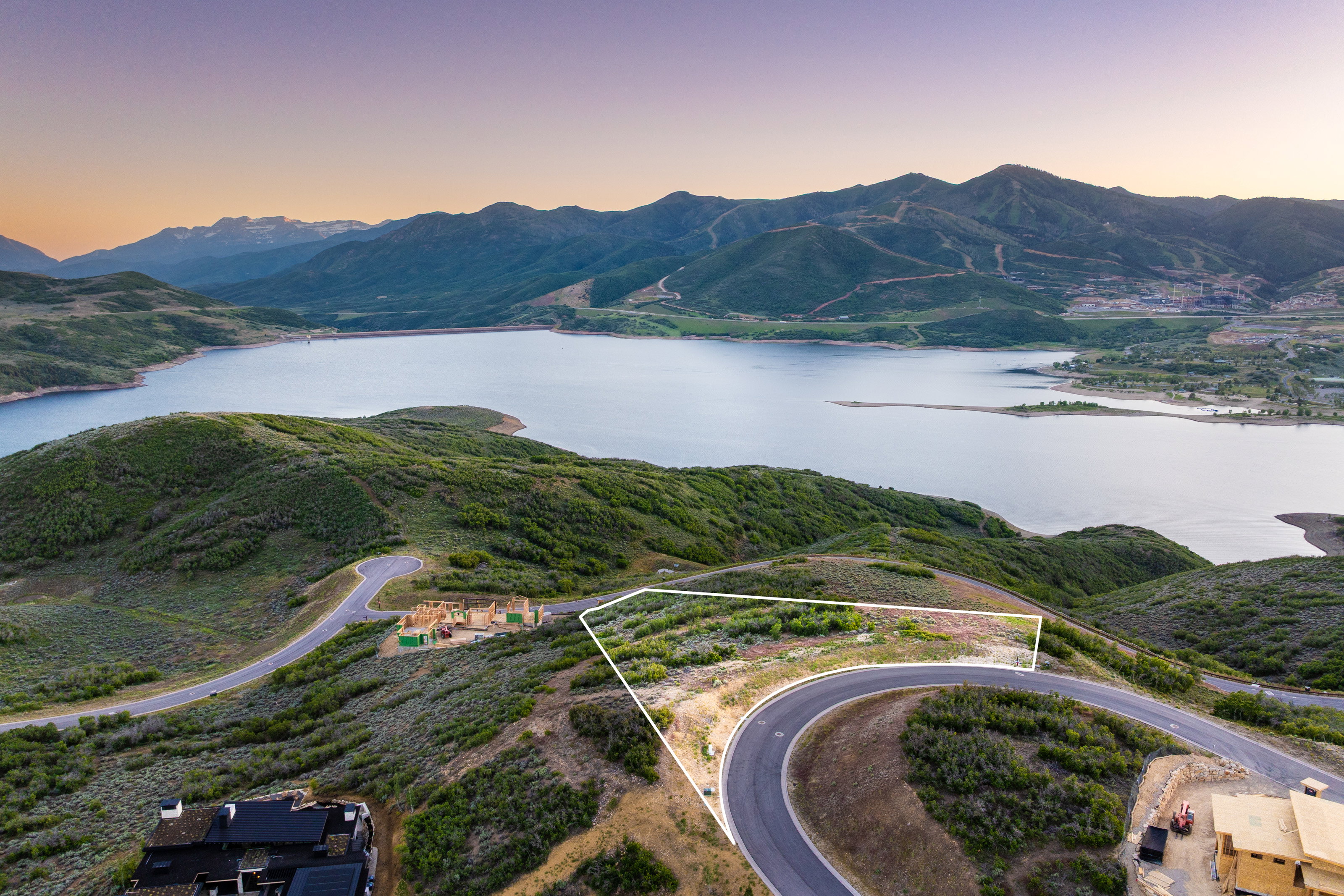 Elevated property parcel featuring a paved road frontage and surrounding natural terrain