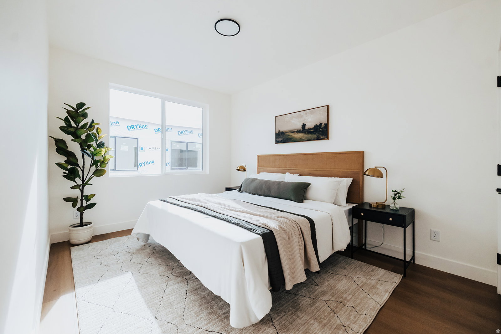 Bright bedroom featuring a large window, recessed lighting, and wood-finish flooring