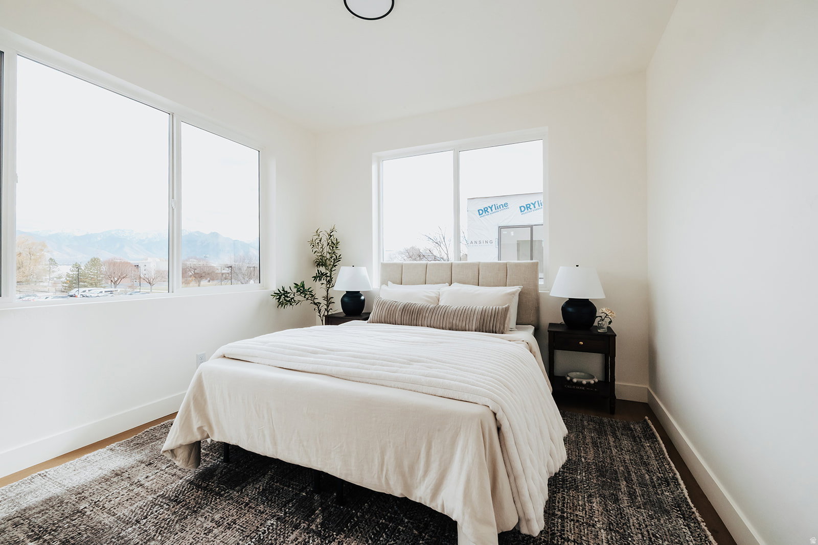 Bedroom featuring expansive windows, recessed lighting, wood-finish flooring, and white baseboards