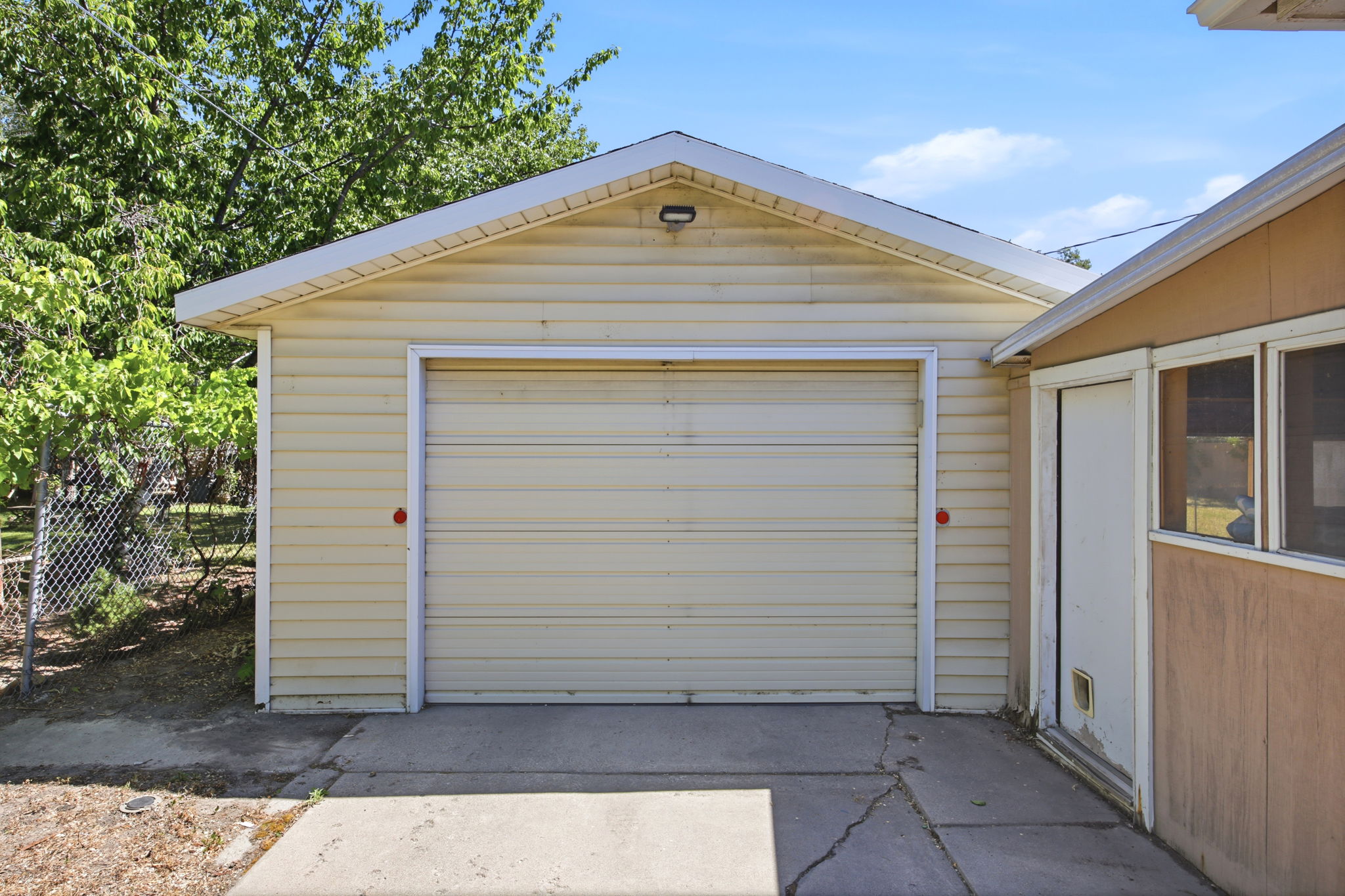 Detached single-car garage featuring horizontal siding and a white trim