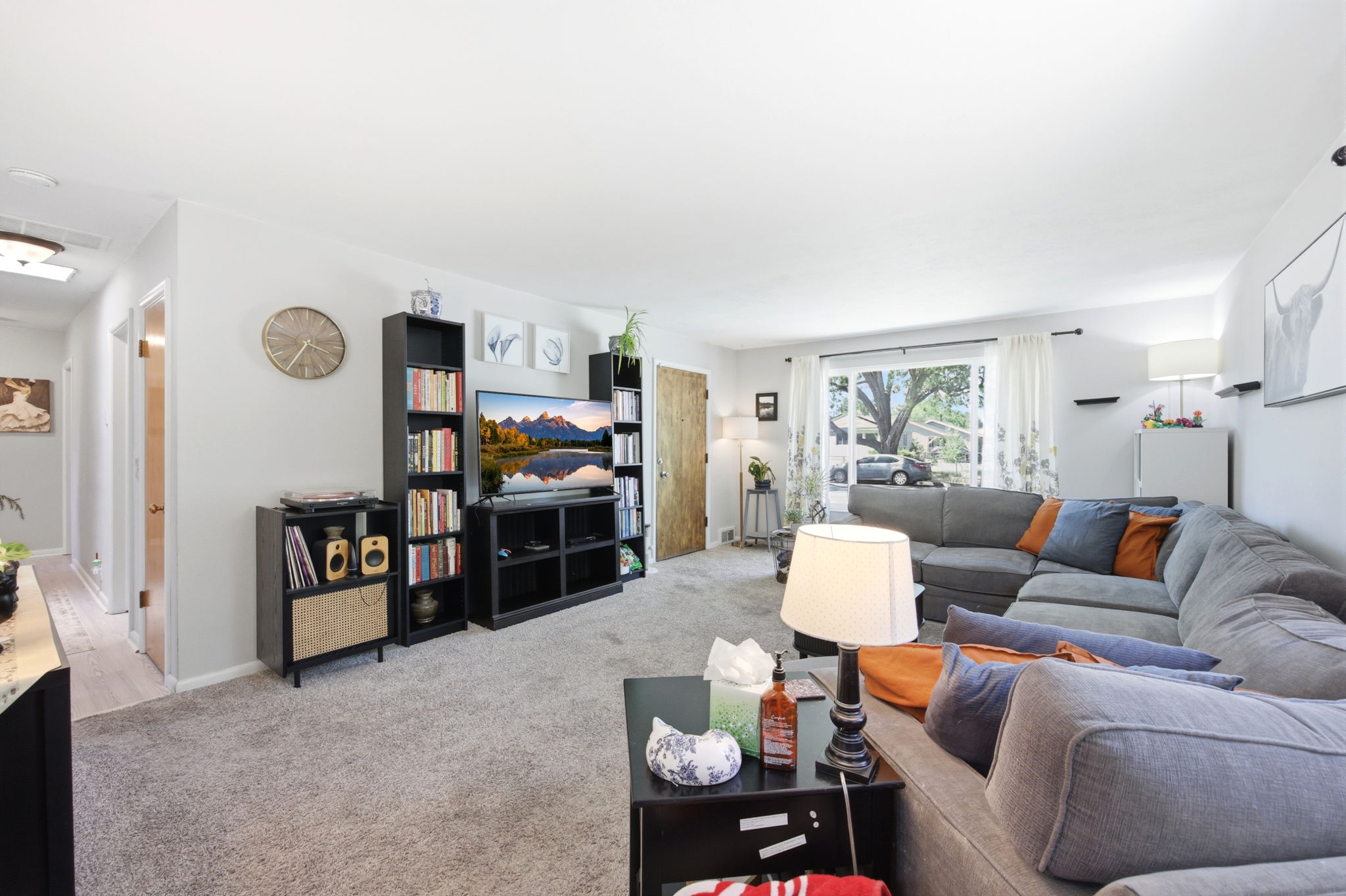 Expansive living area with neutral wall tones and plush gray carpeting
