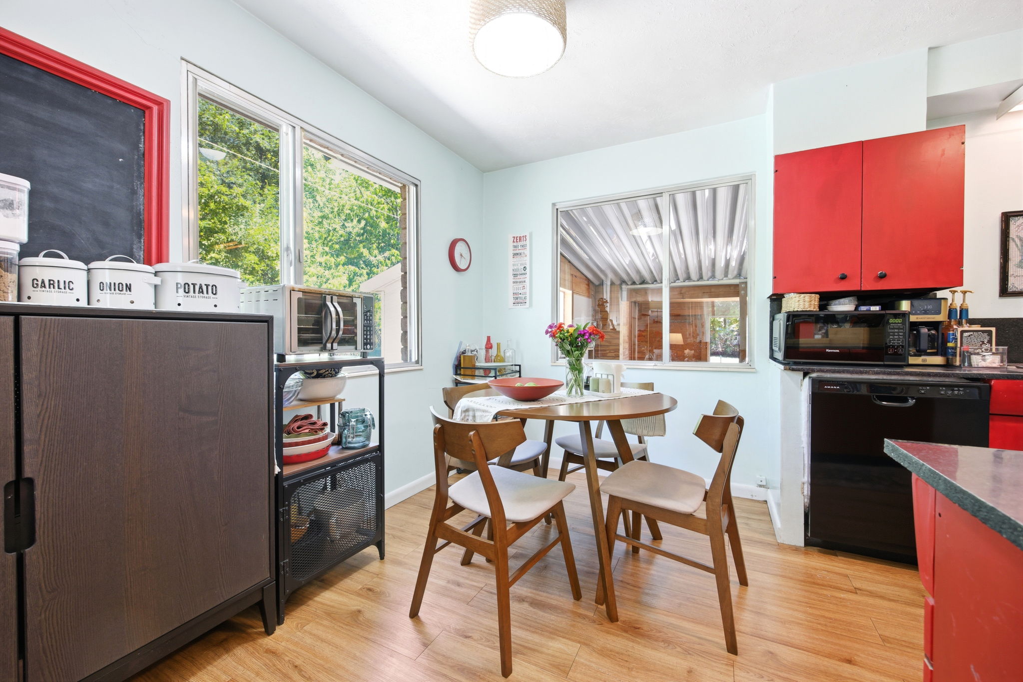 Kitchen featuring wood-finish flooring, red cabinetry, and dual windows