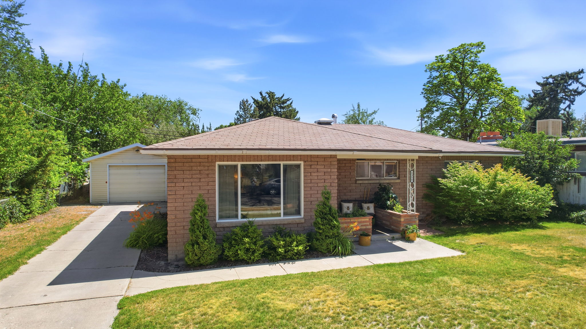 Brick exterior featuring a single-story design and a brown shingle roof