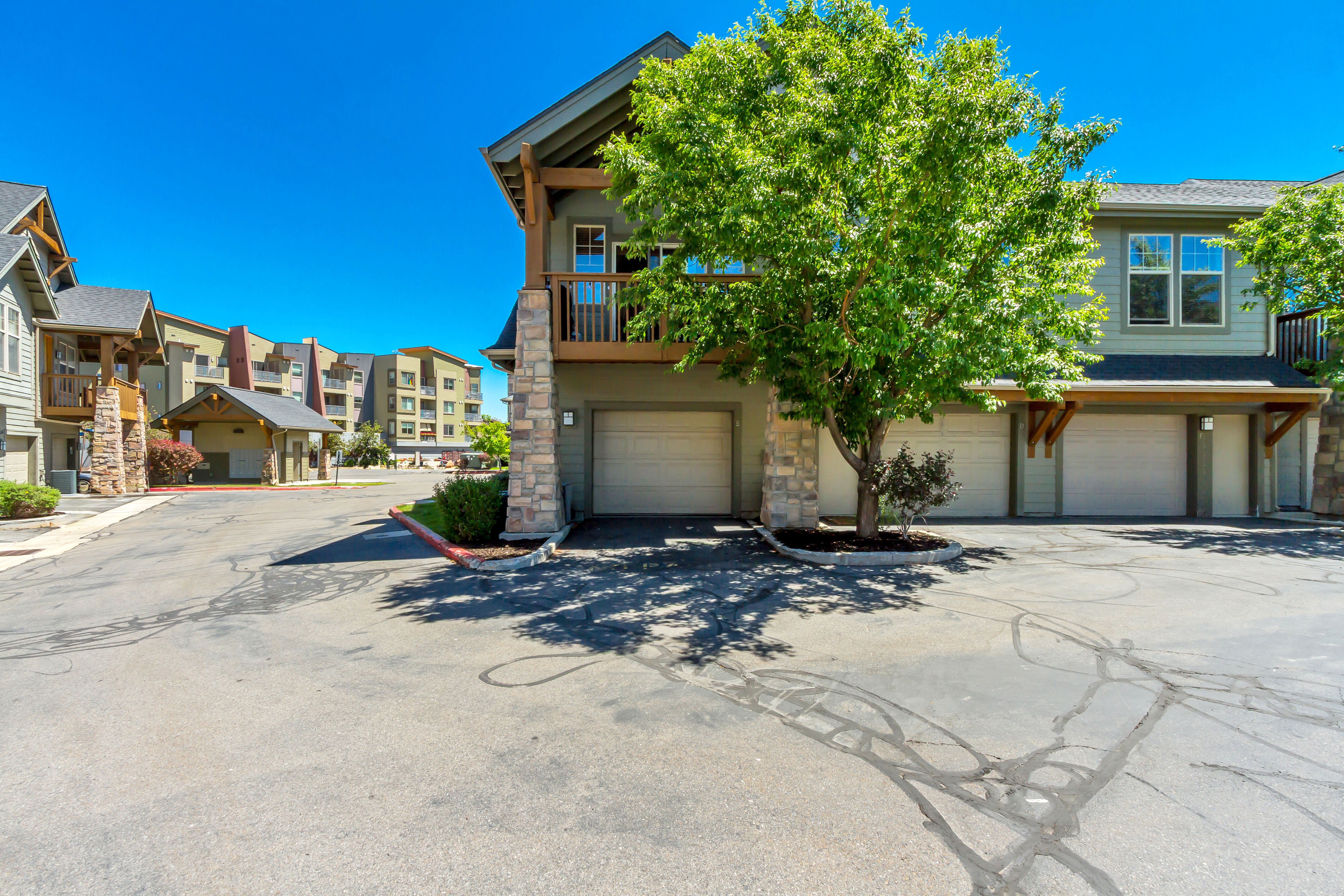 Exterior features include multiple garages, stone veneer accents, and wood-beam detailing