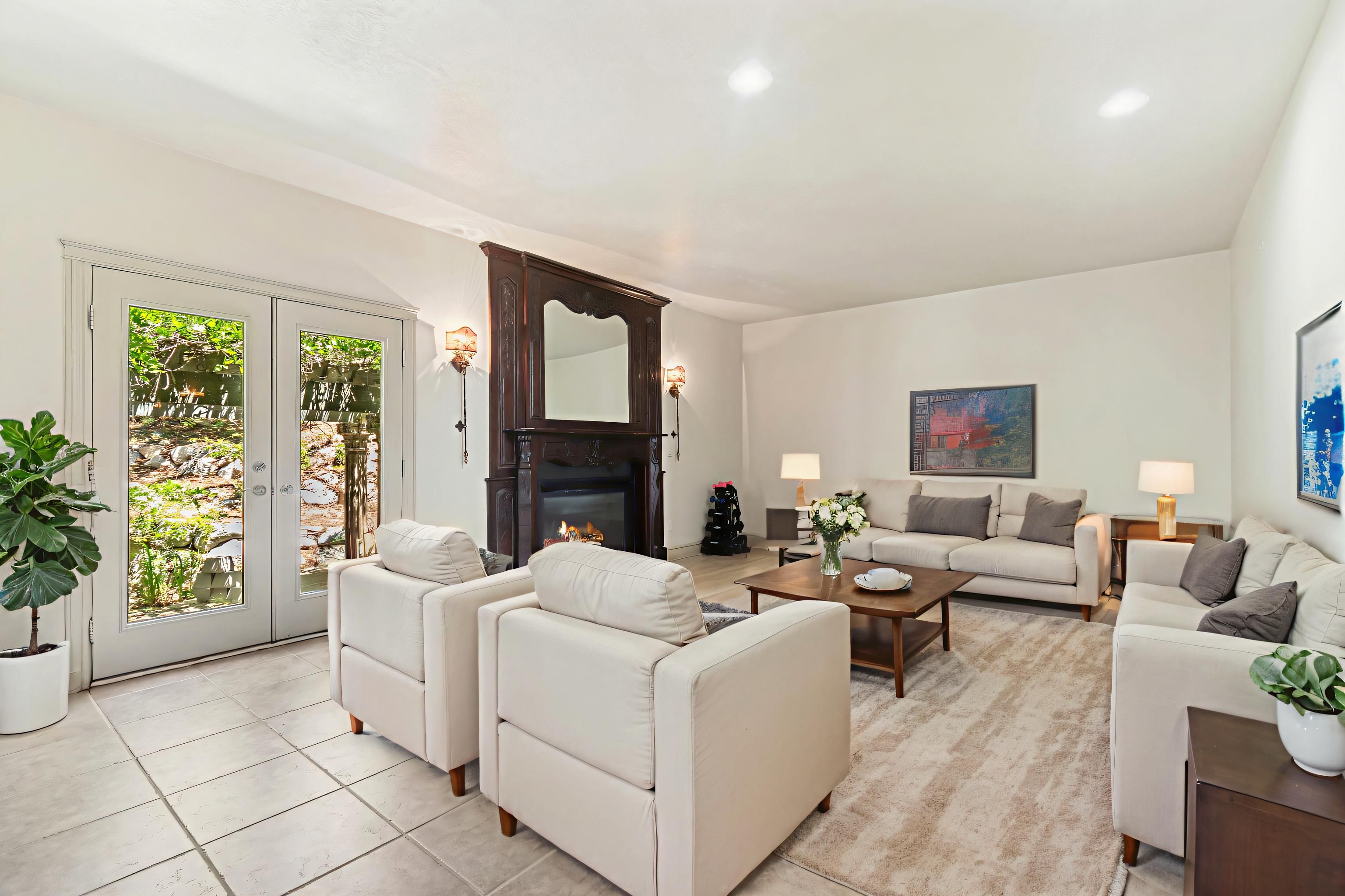Spacious living area featuring a decorative fireplace with an ornate wood mantle, recessed lighting, and light-toned tile flooring