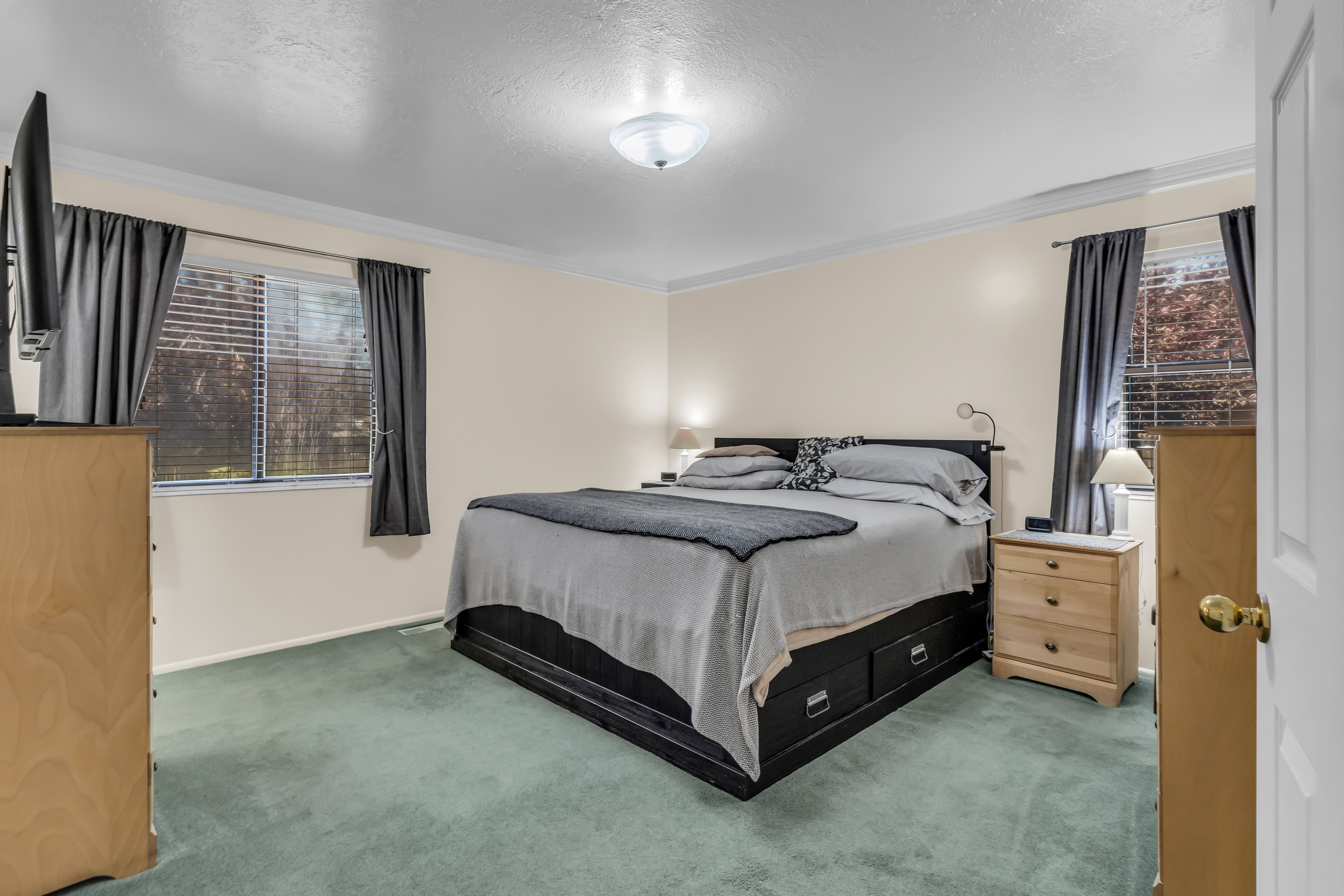 Carpeted bedroom with neutral-toned walls, a single window, and crown molding